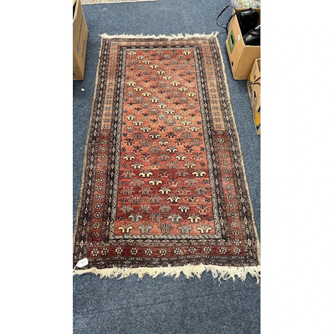 Eastern red ground rug, the field decorated with stylised fl...