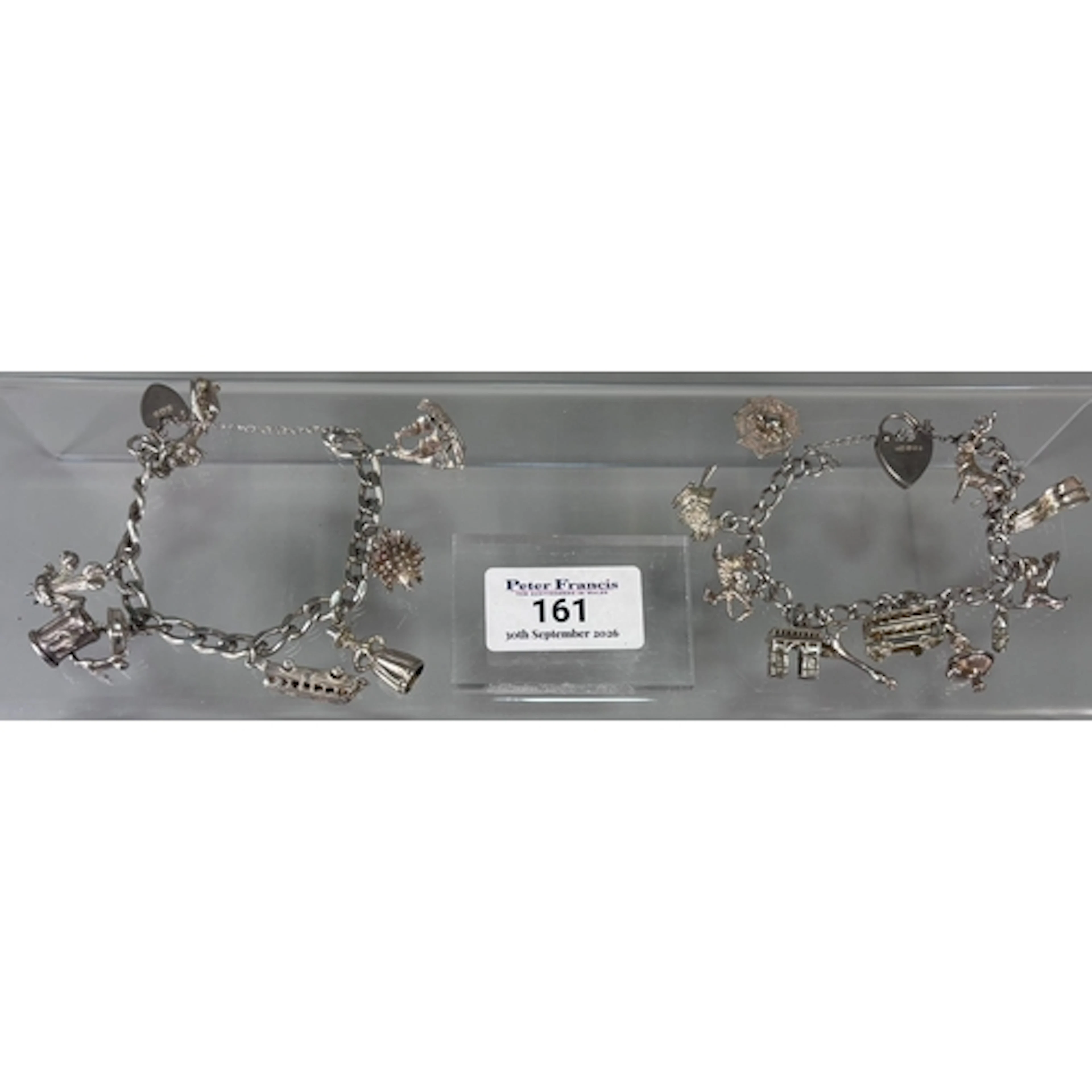 Two silver charm bracelets with a collection of assorted cha...