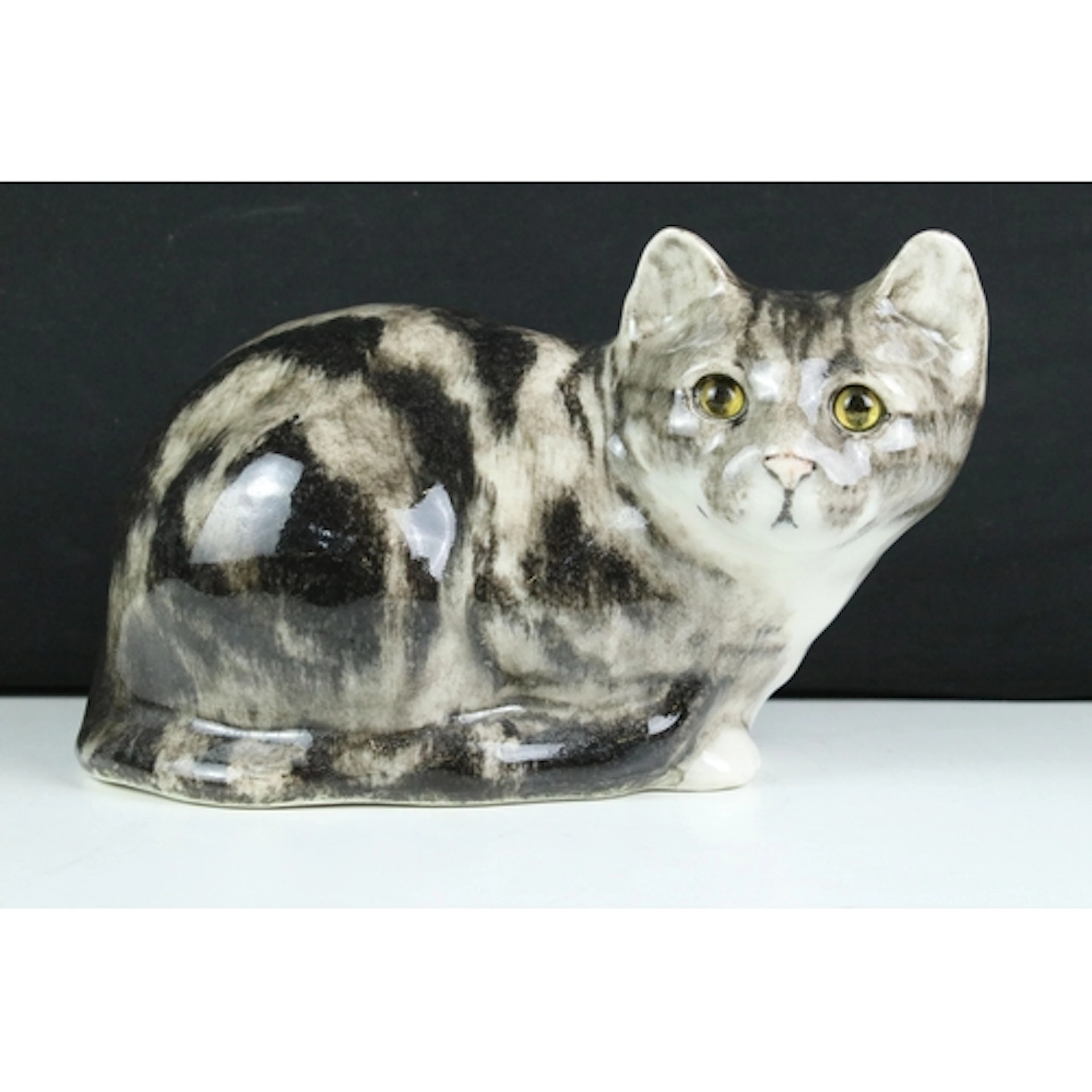 Winstanley figurine of a crouching tabby cat with yellow gla...