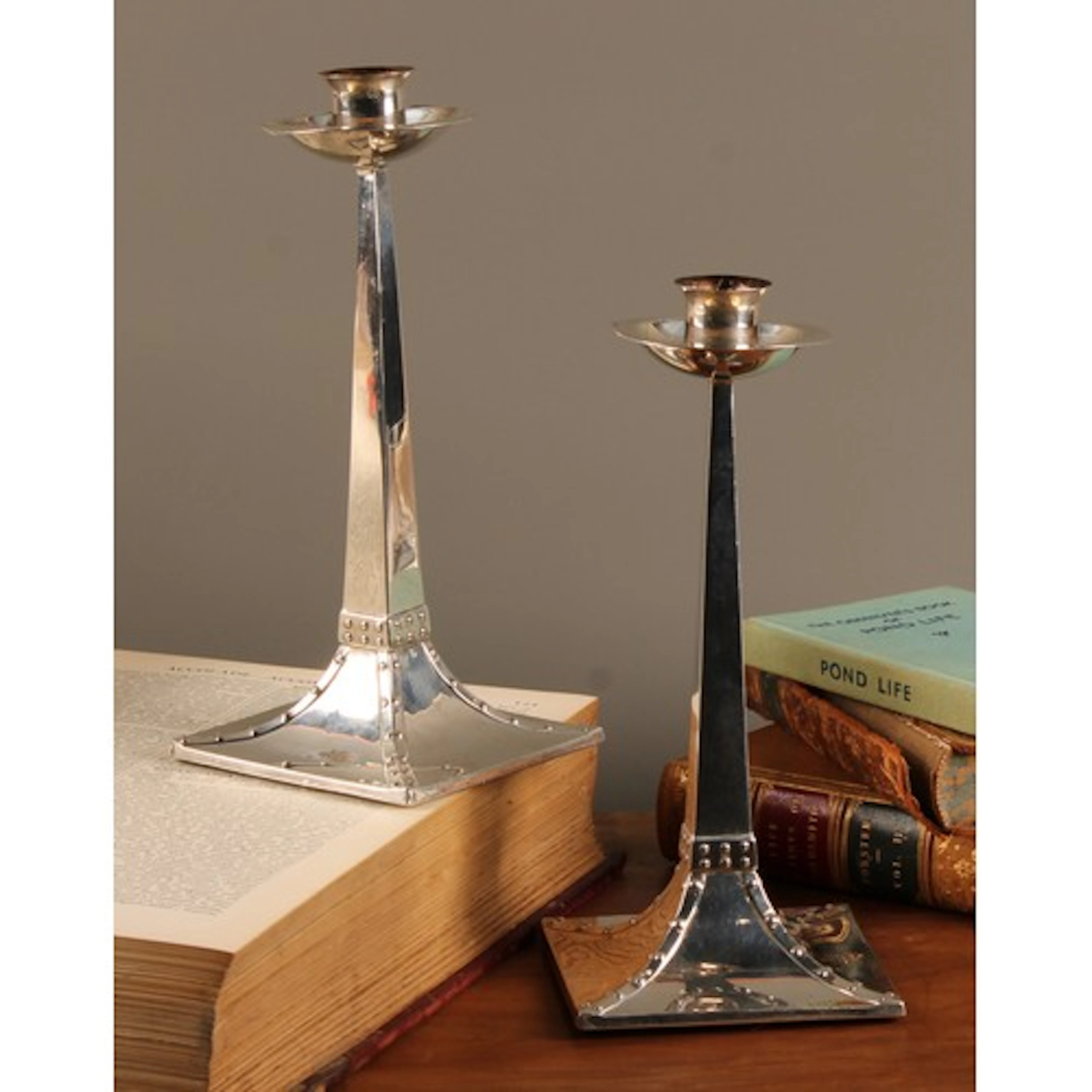A pair of Arts and Crafts silver candlesticks, the design at...