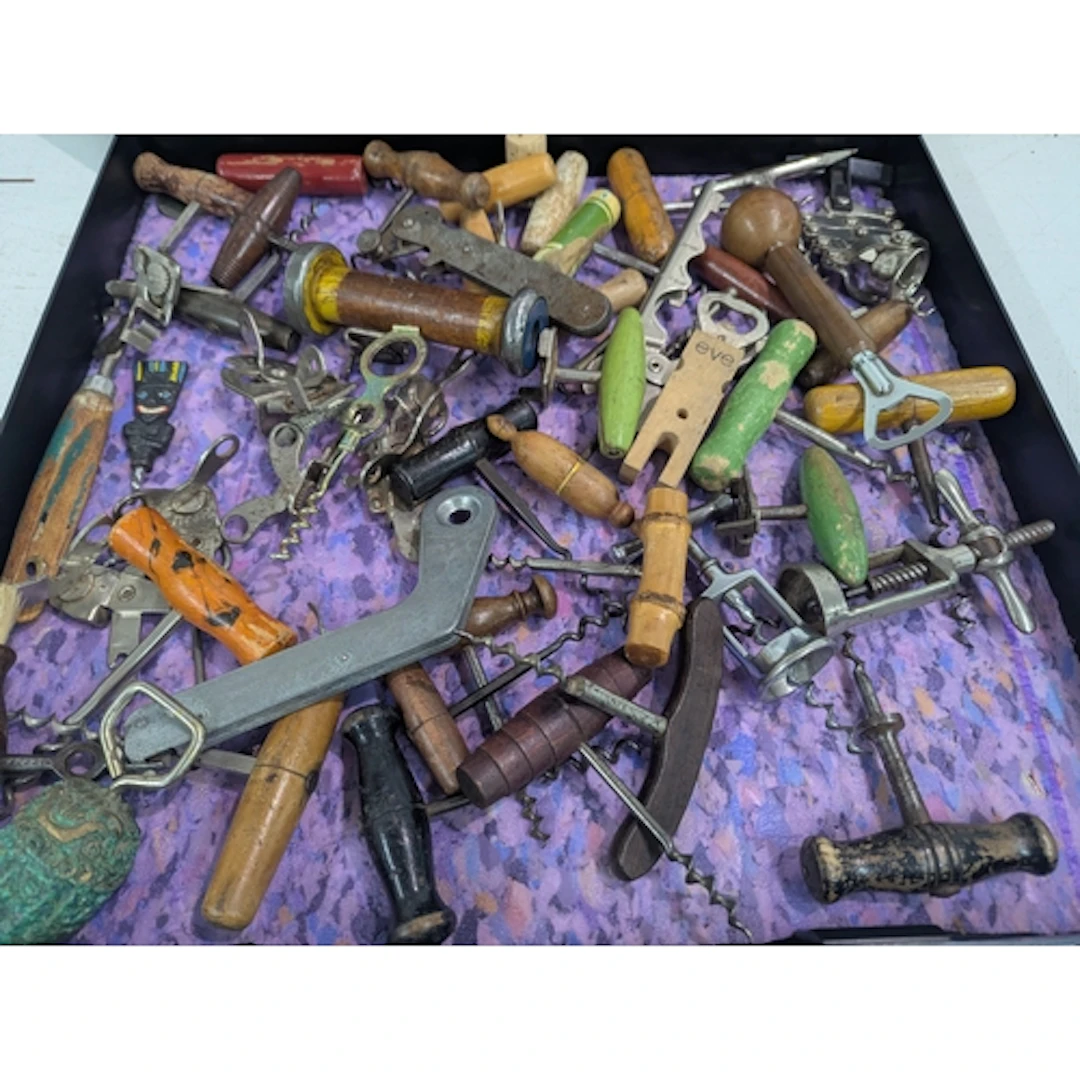 A collection of vintage corkscrews and bottle openers, mainl...
