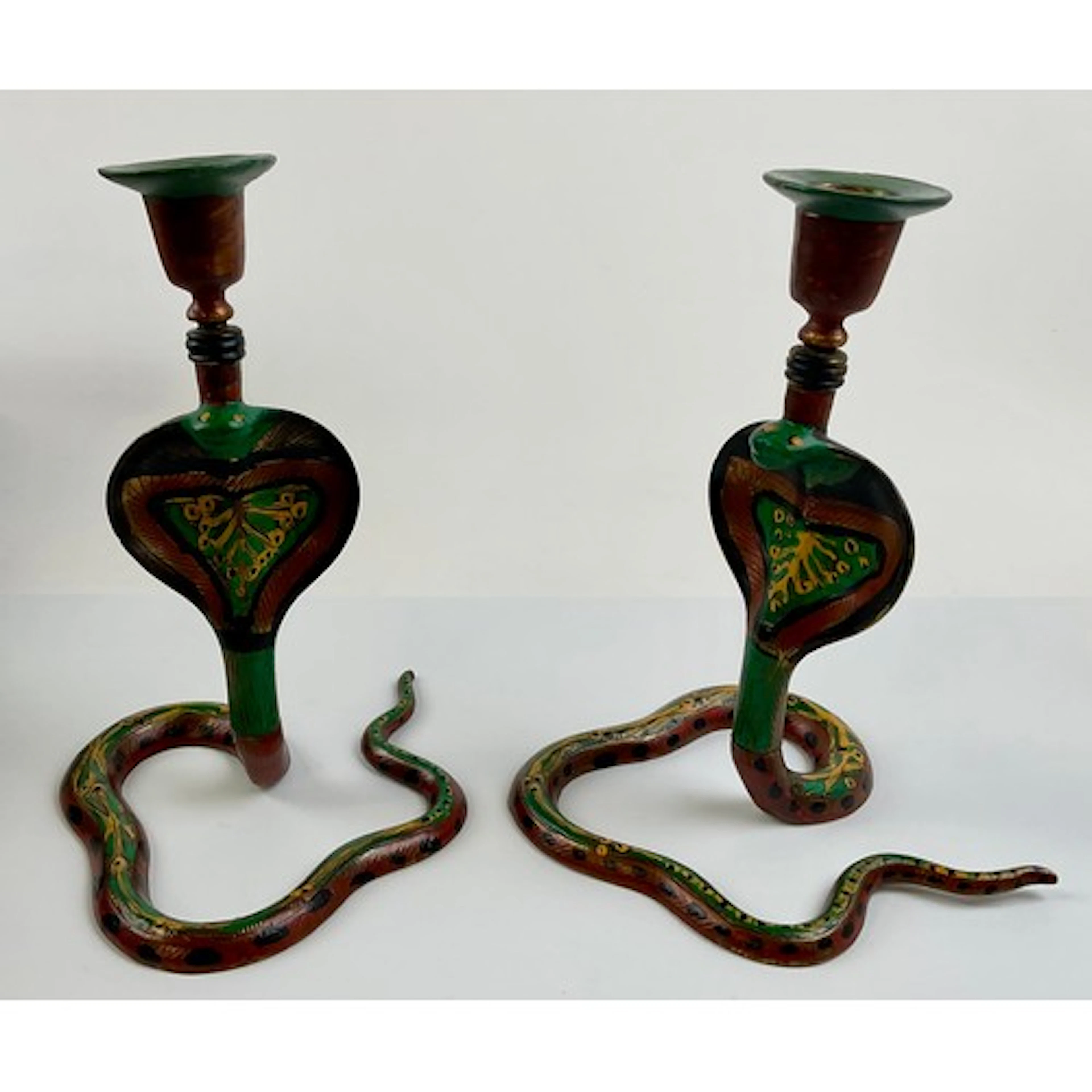 A pair of Indian polychrome painted brass candlesticks, casr...