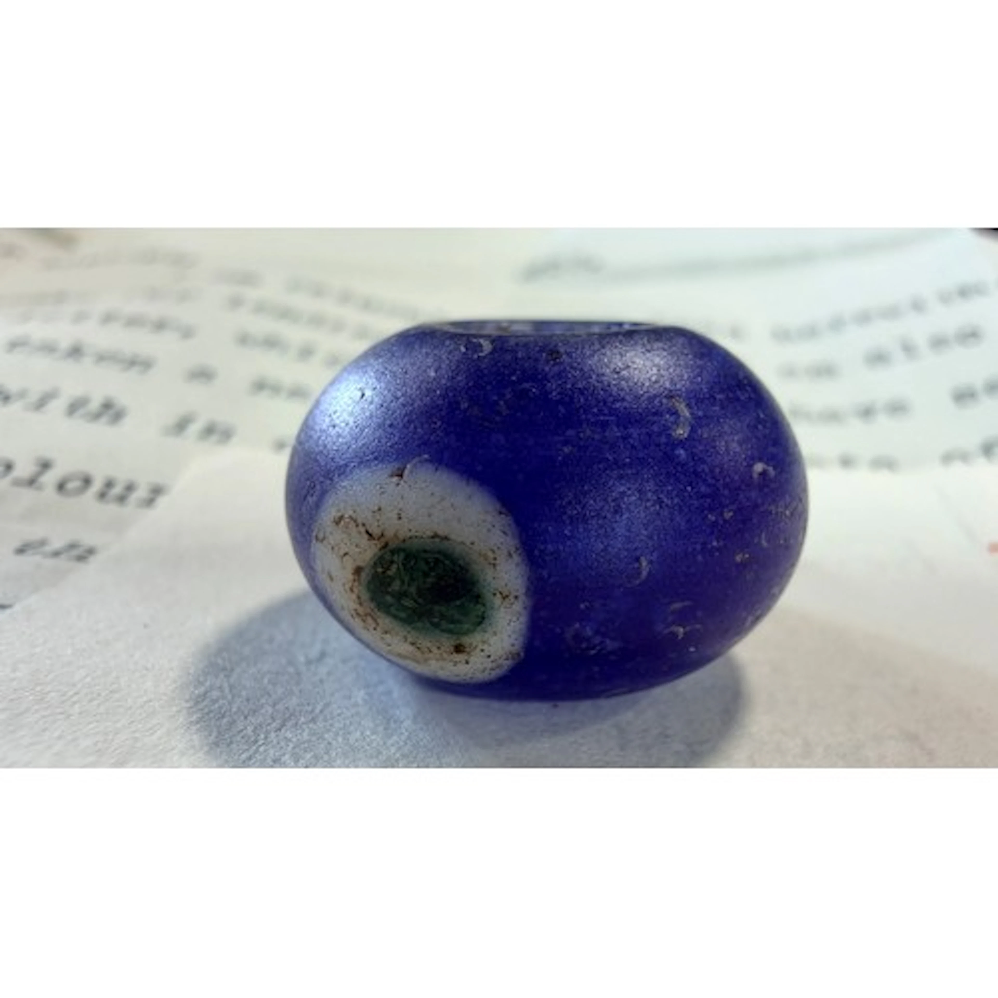 A Roman blue glass bead, discovered during archaeological ex...