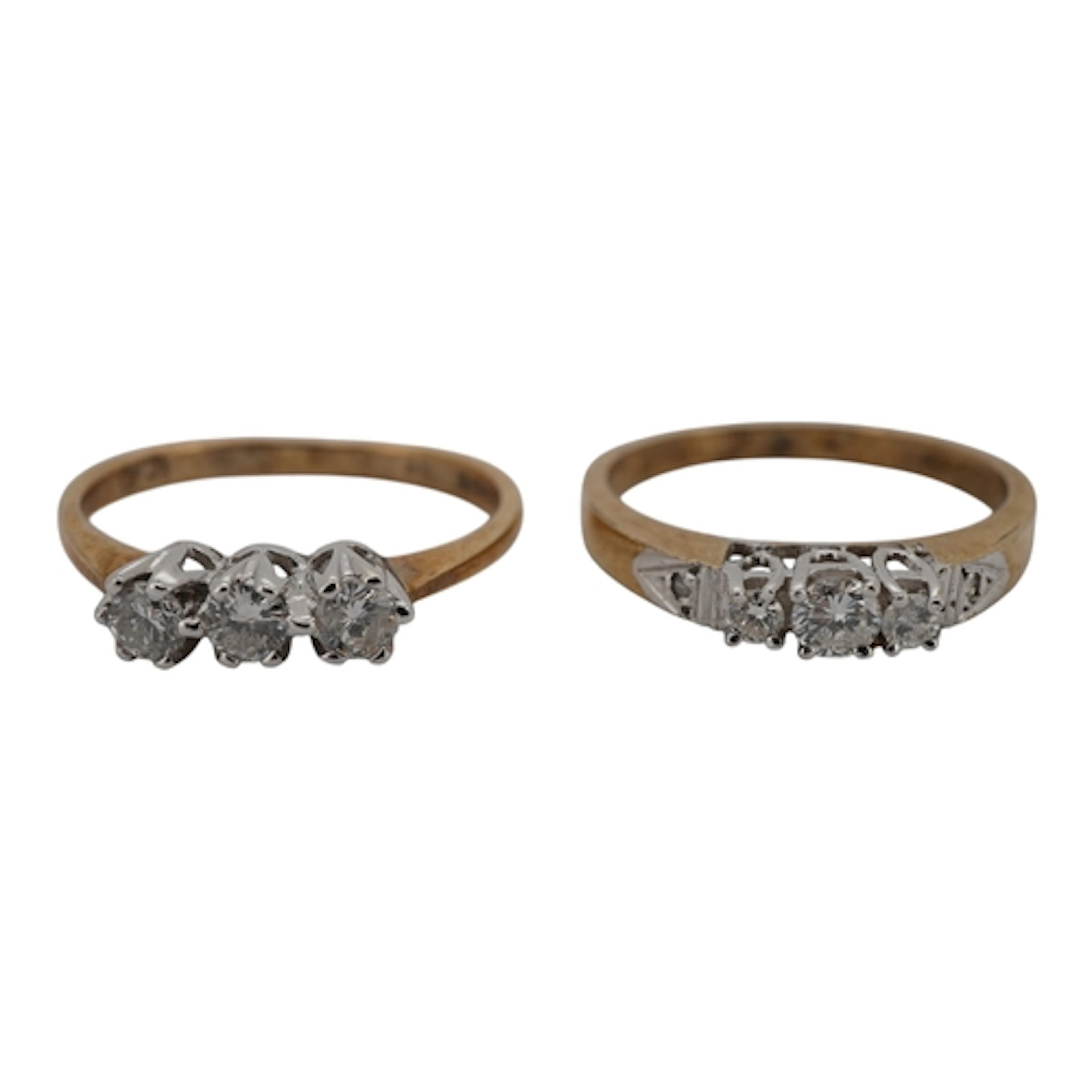 Two three-stone diamond rings, each set with a sequence of b...