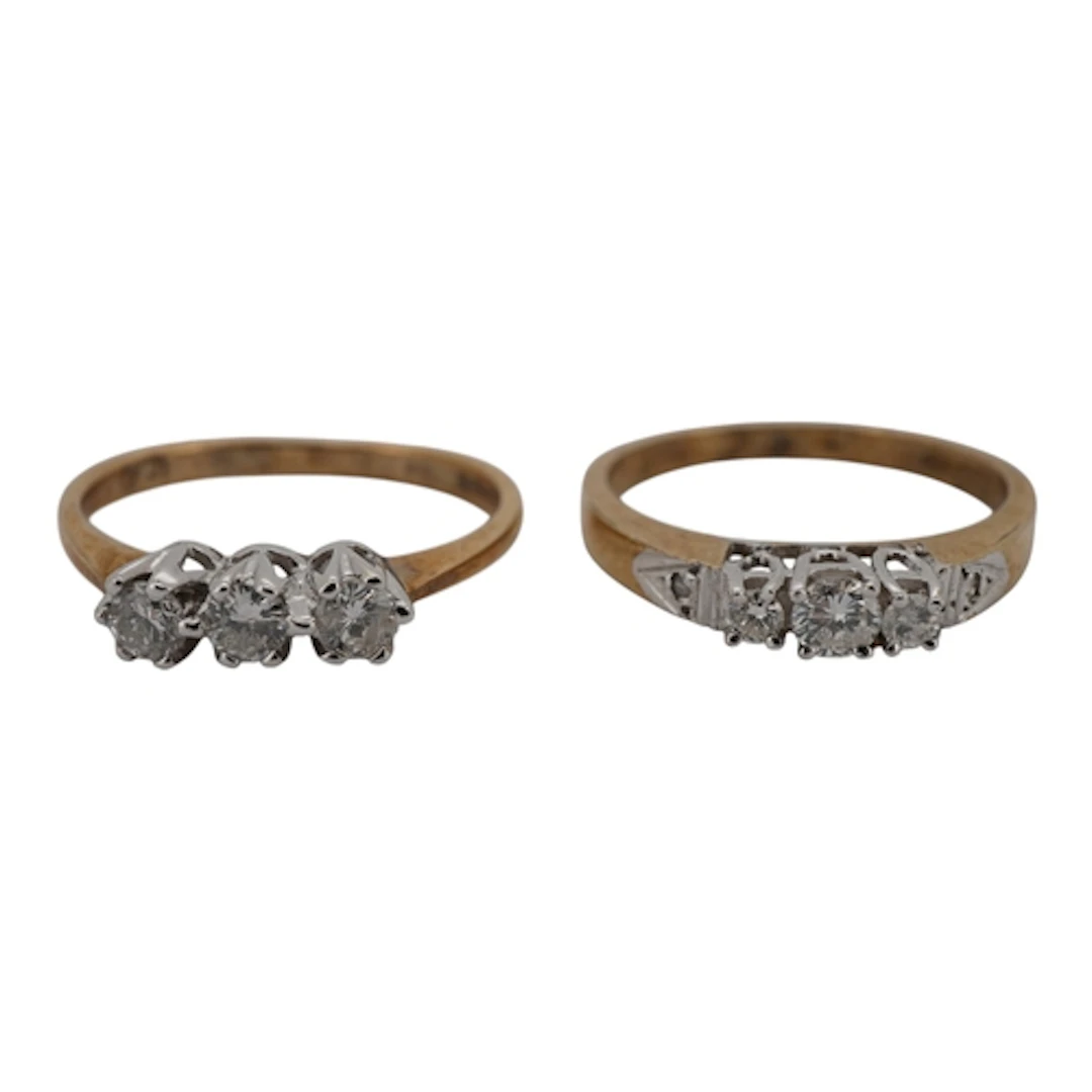 Two three-stone diamond rings, each set with a sequence of b...