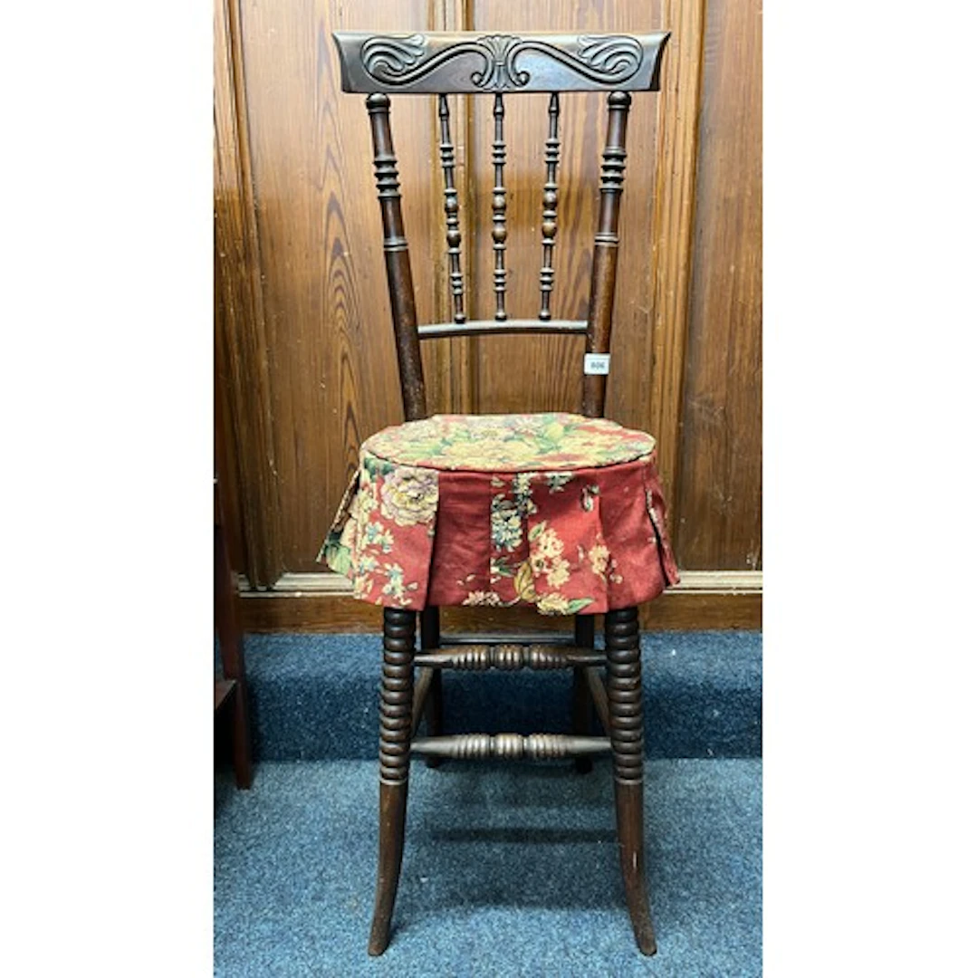 Antique mahogany chair with carved design and spindle back