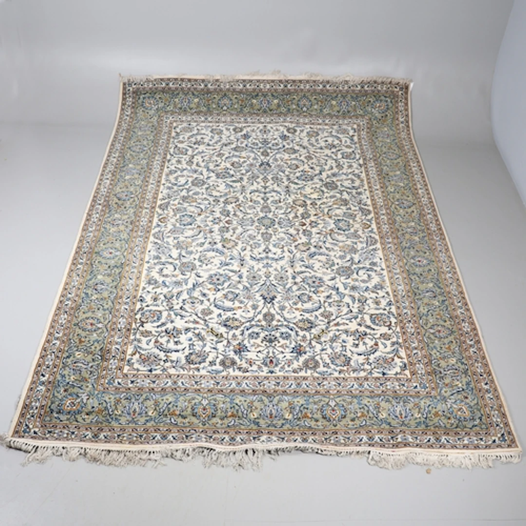 A KASHAN CARPET, CIRCA 1970. The cream field with an all ove...