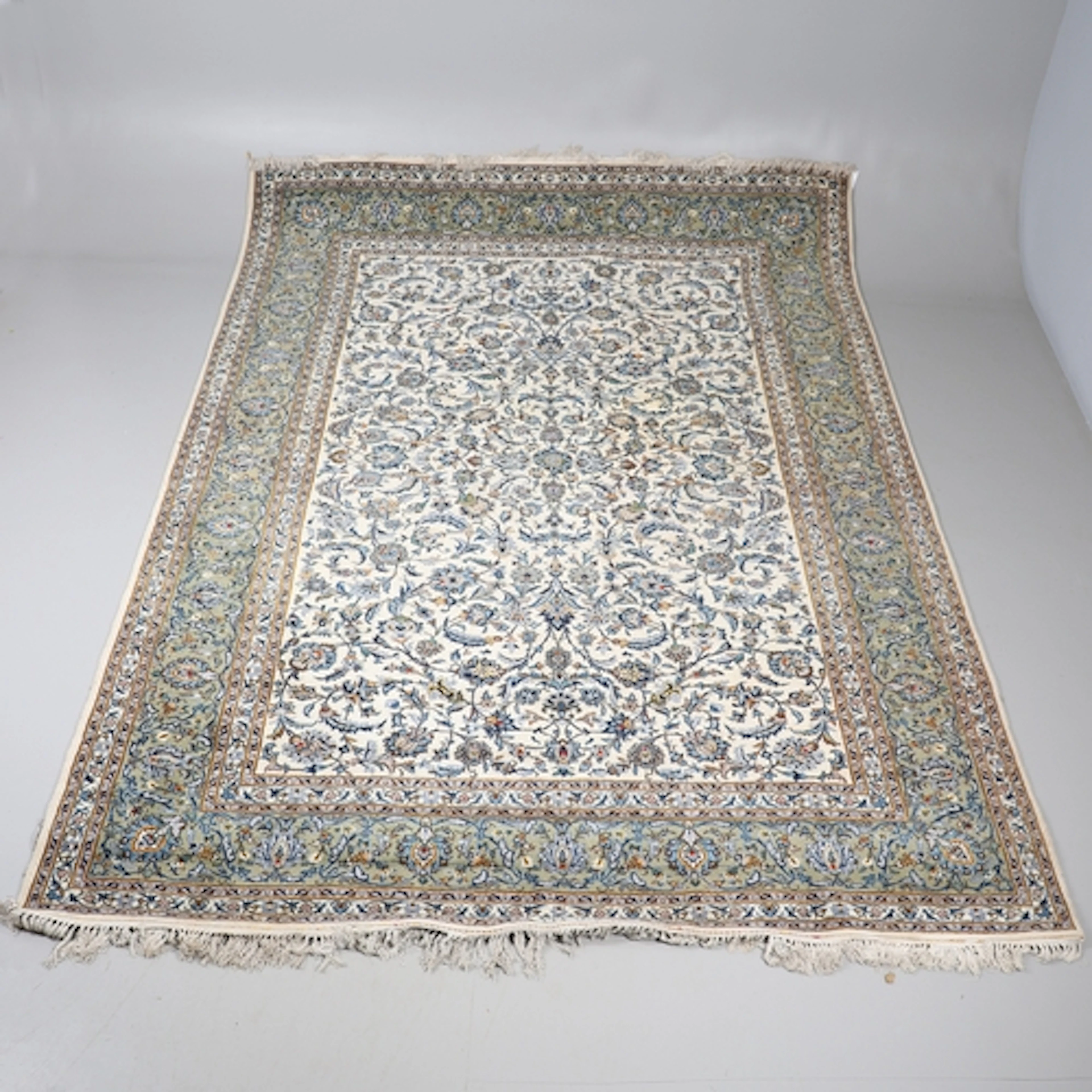 A KASHAN CARPET, CIRCA 1970. The cream field with an all ove...