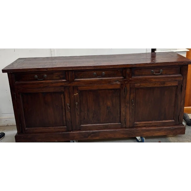 A dark wood side board with three drawers over a three door ...