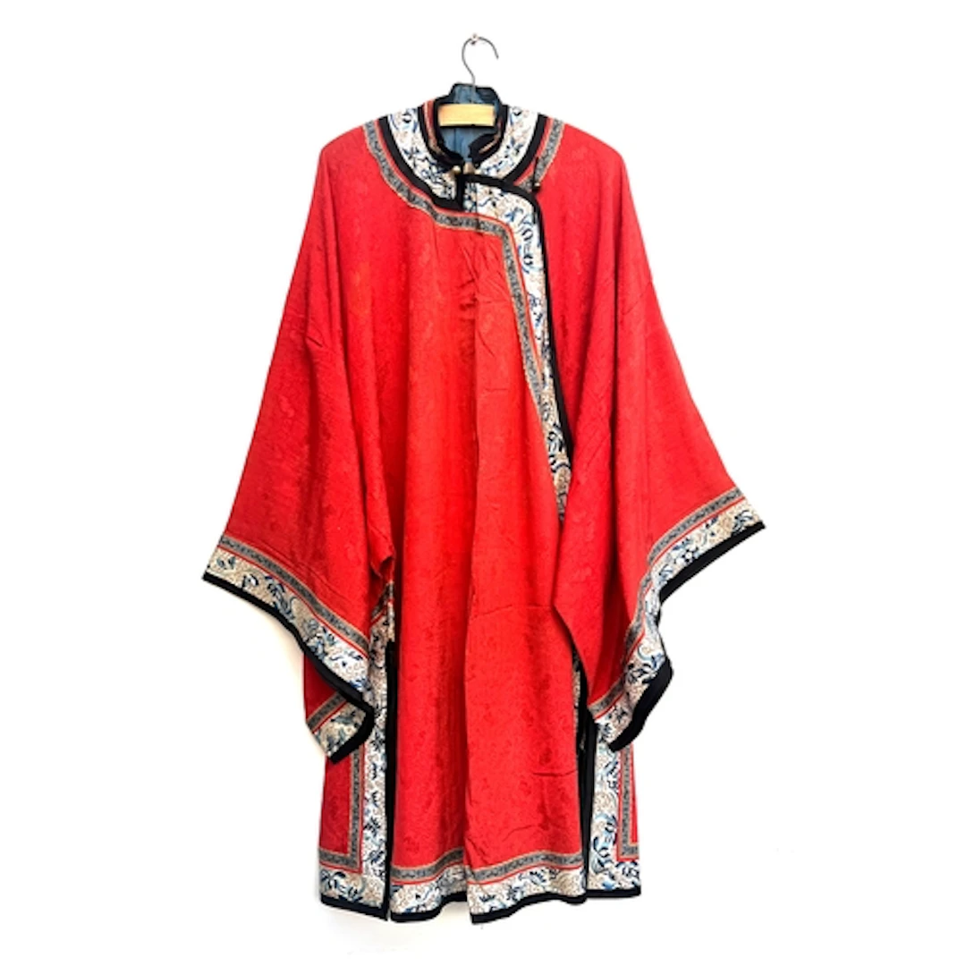 An antique Chinese red damask silk robe with cream border em...