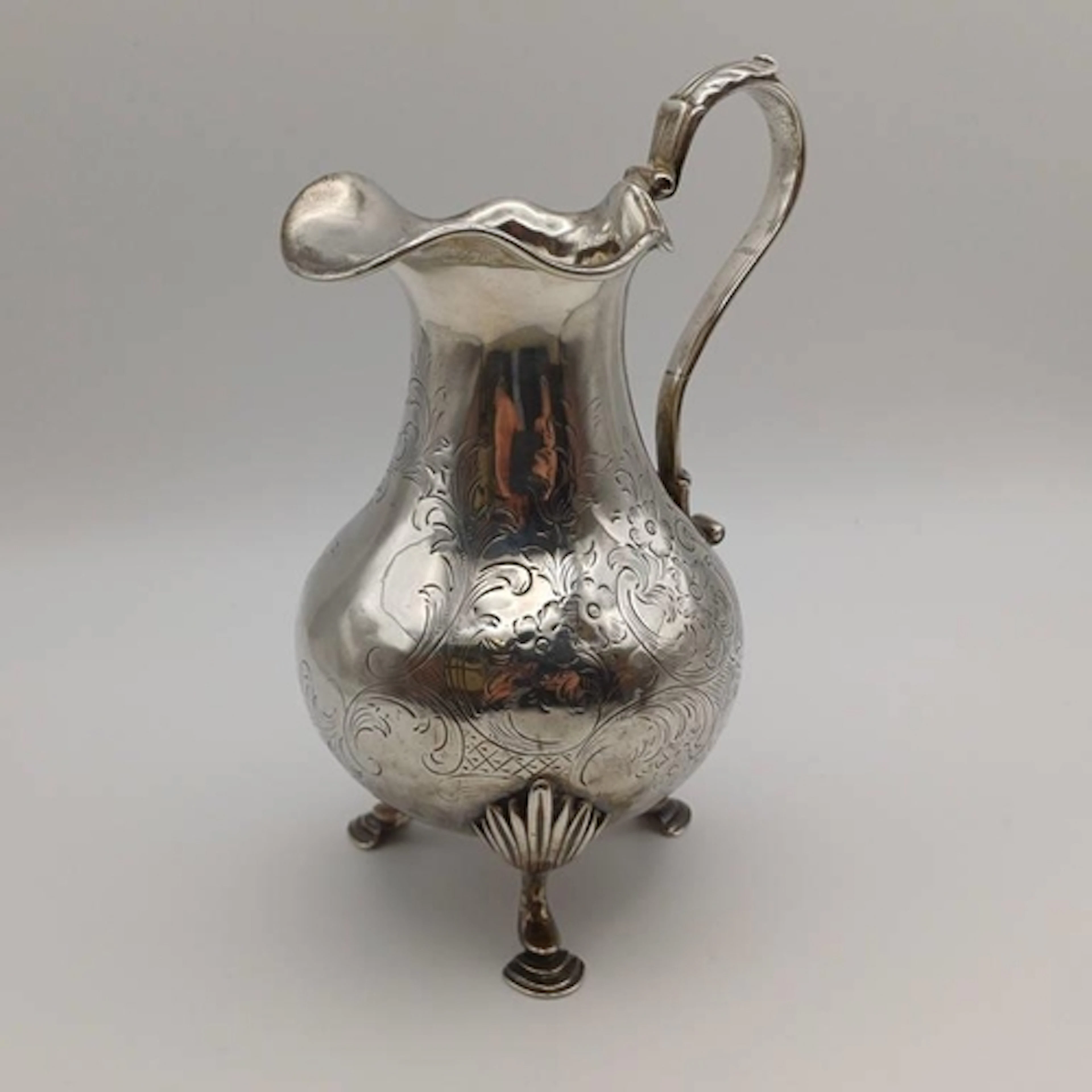 A VICTORIAN SILVER MILK JUG WITH ETCHED FLORAL DECORATION ON...