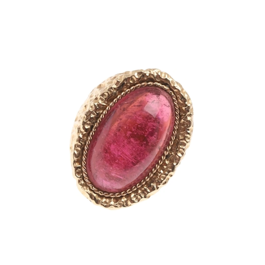 A TOURMALINE AND 14CT GOLD RING. the oval-shaped cabochon to...