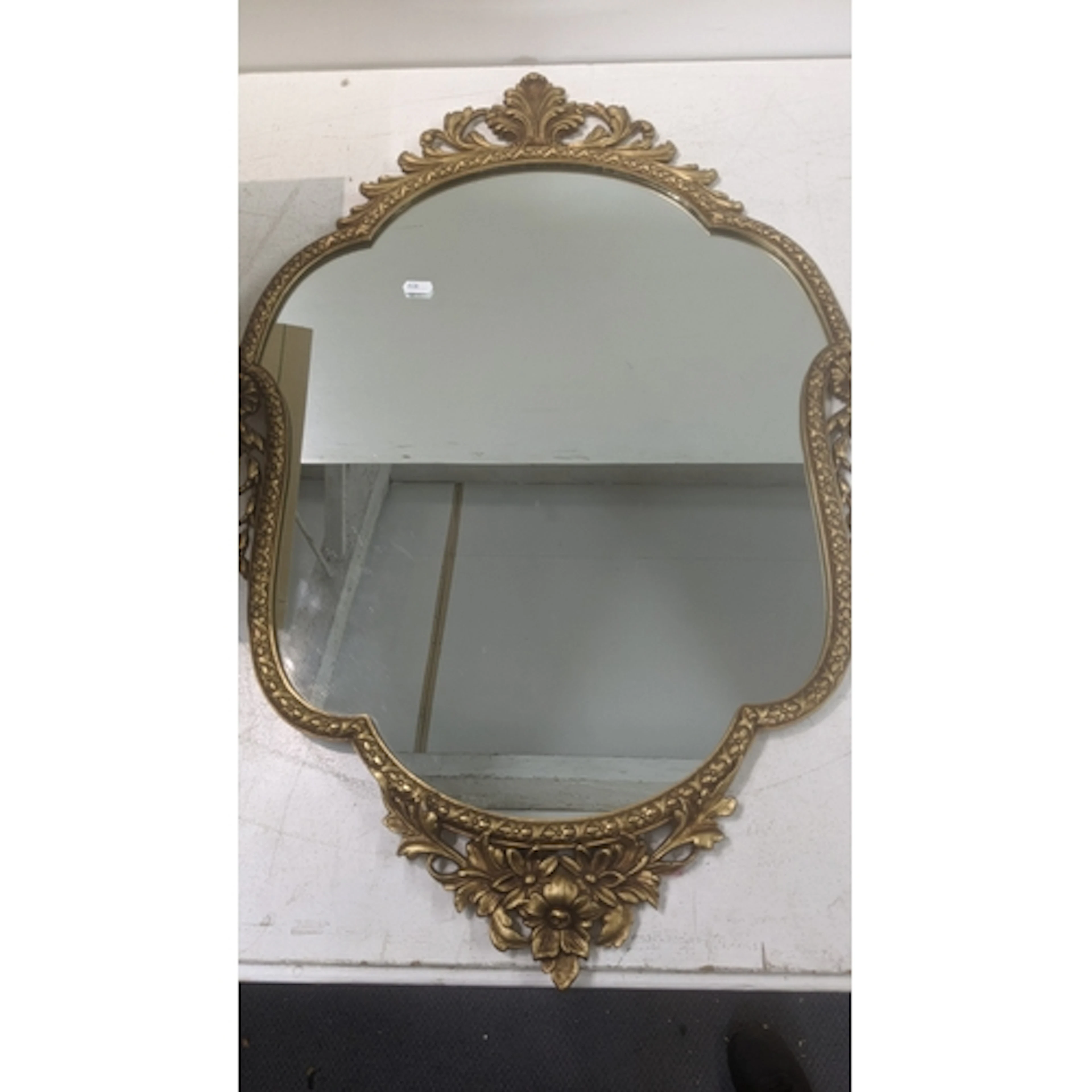 A 20th century reproduction baroque style gilt framed mirror...