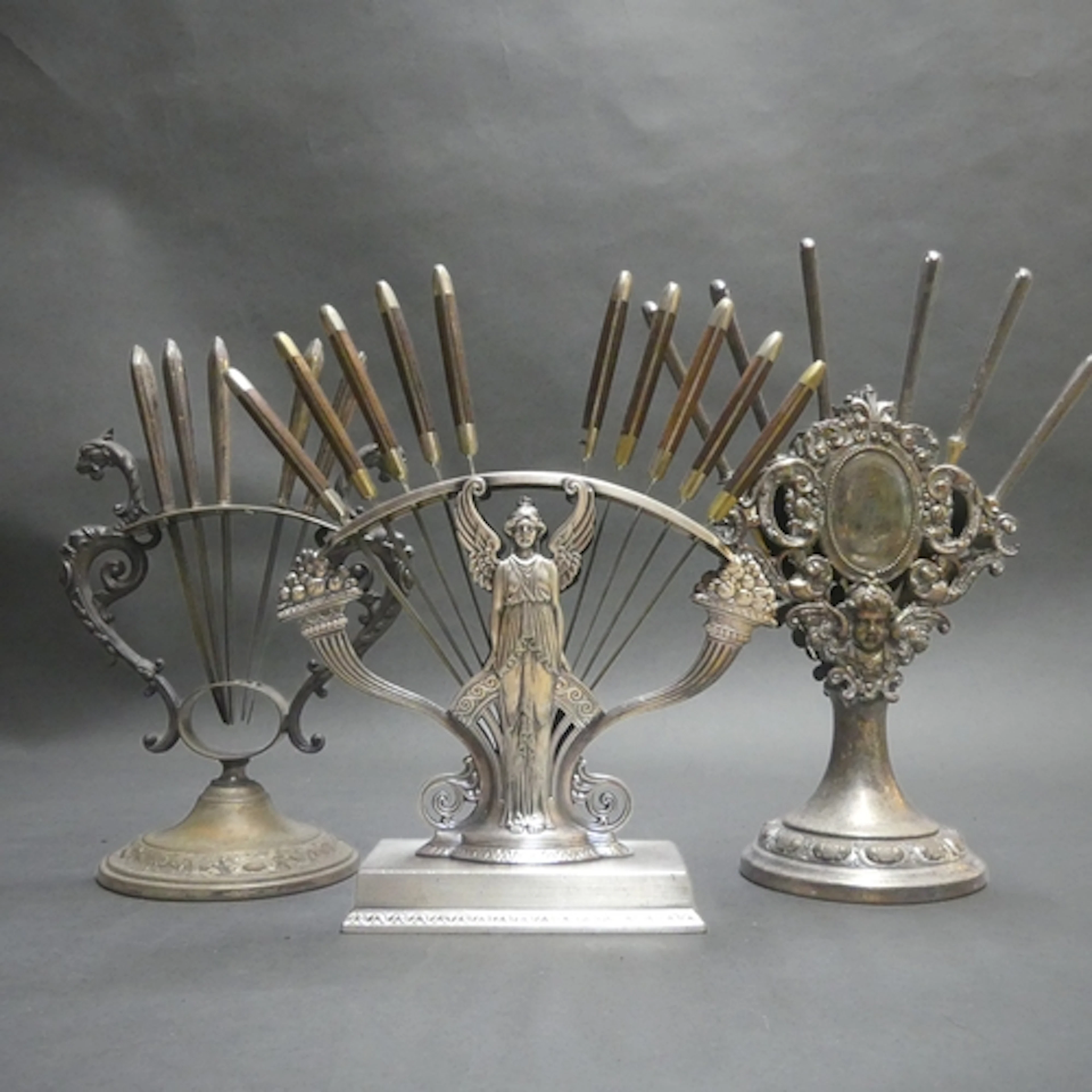 Three Art Nouveau design silver plated knife stands of varyi...