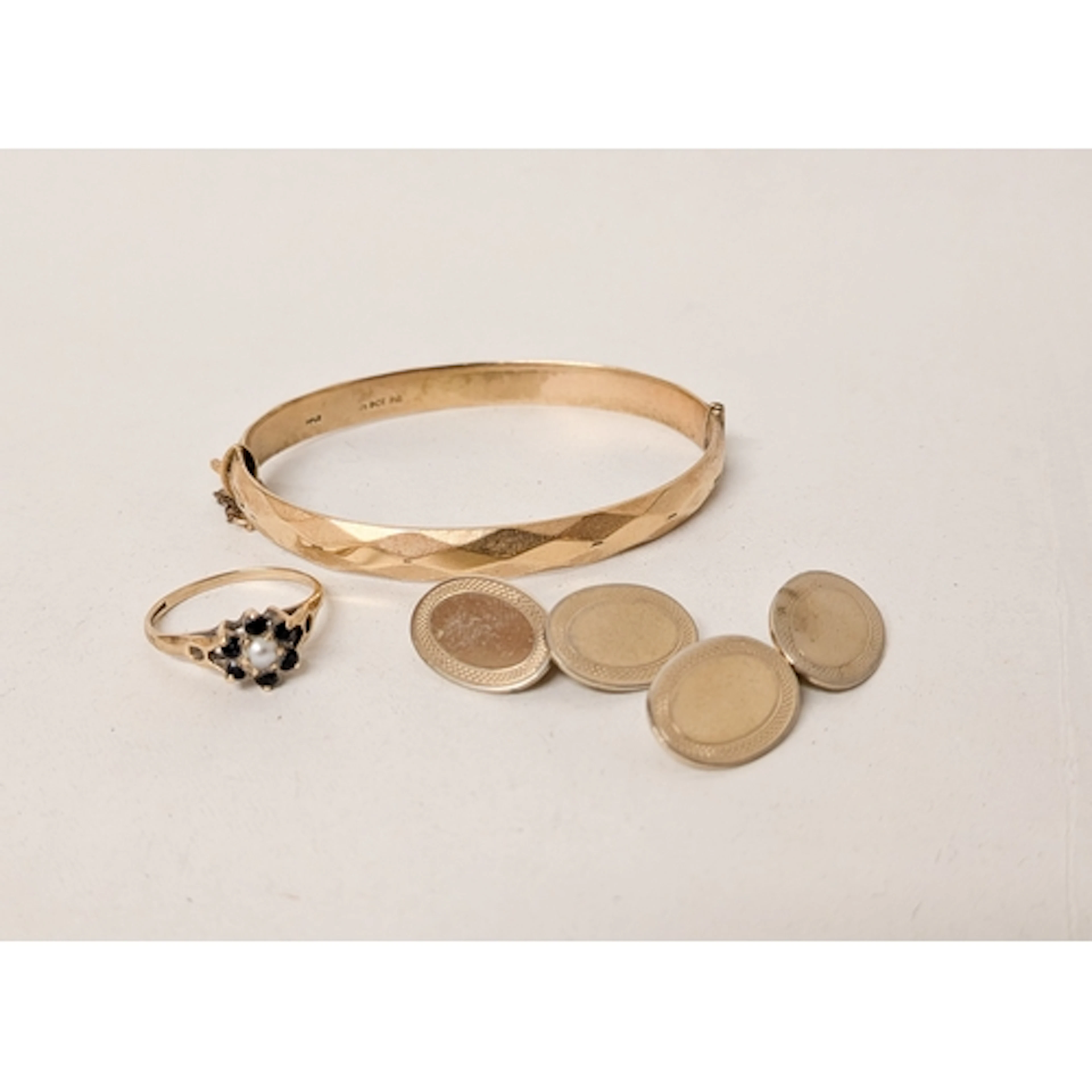 A rolled gold bangle together with a 9ct gold sapphire and p...