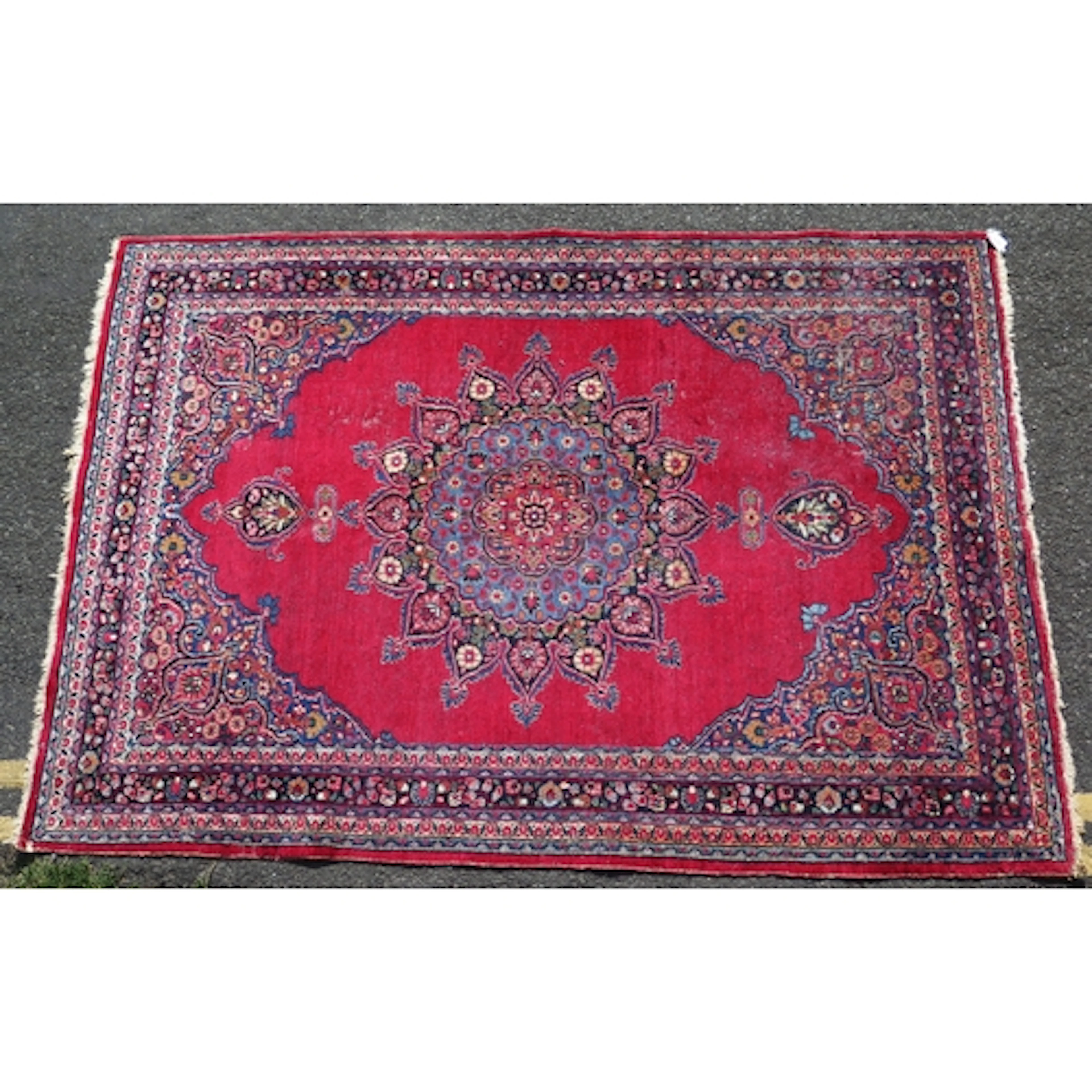 A meshed rug, the wine red field with central floral pole me...