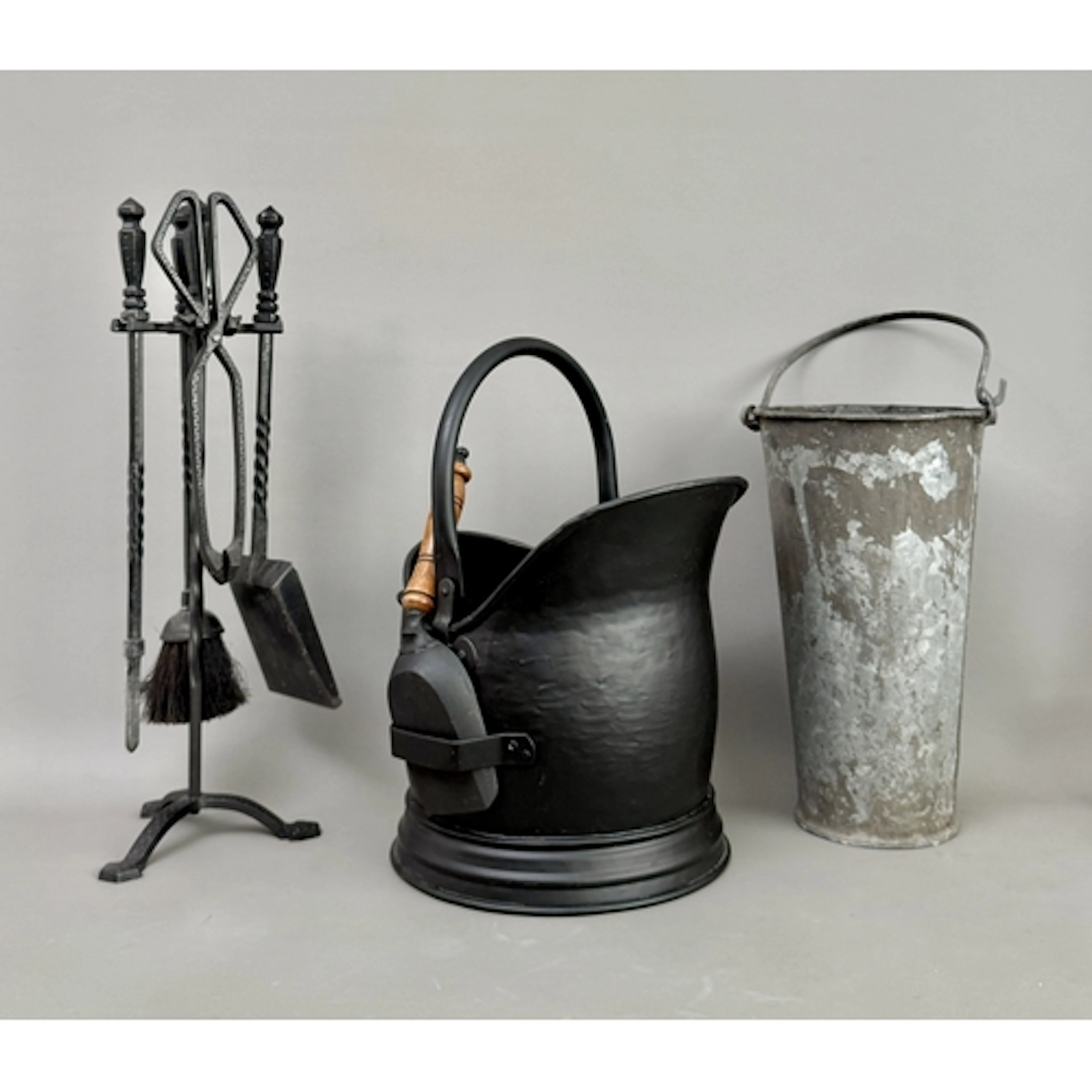 A contemporary black painted metal helmet shaped coal scuttl...