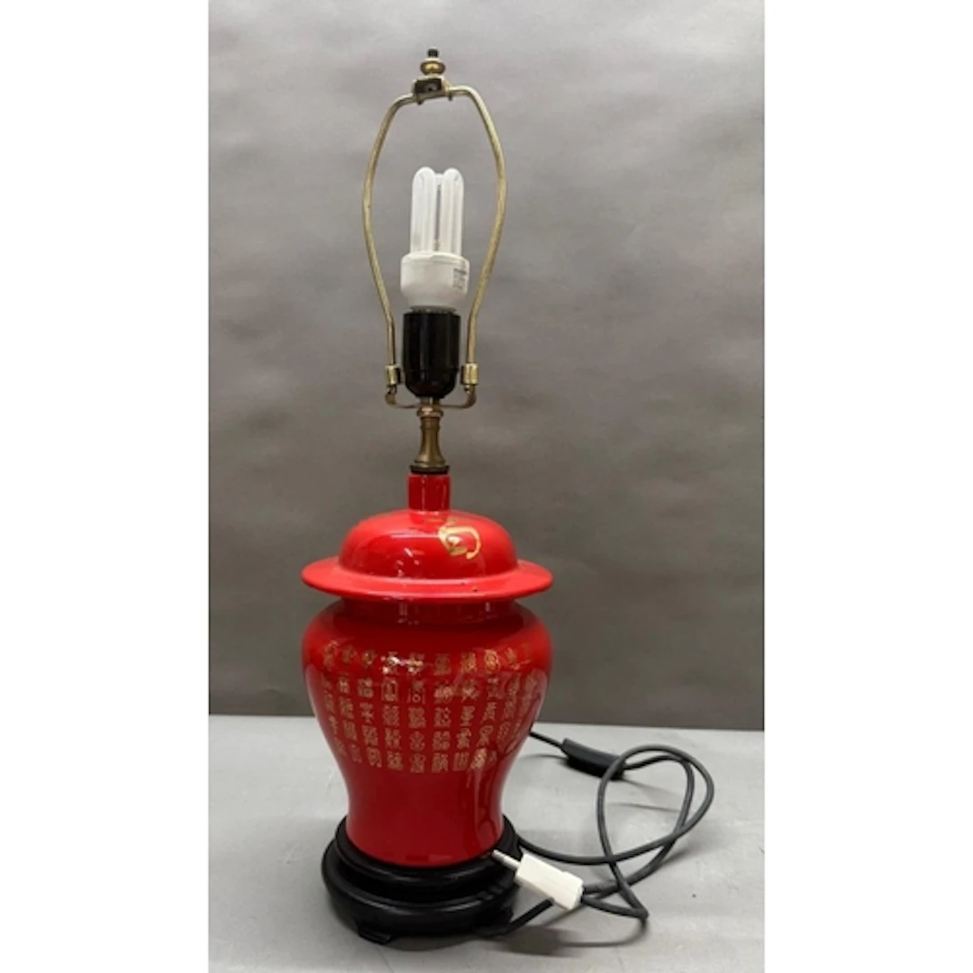 A Chinese ginger jar table lamp in red and with gilt charact...