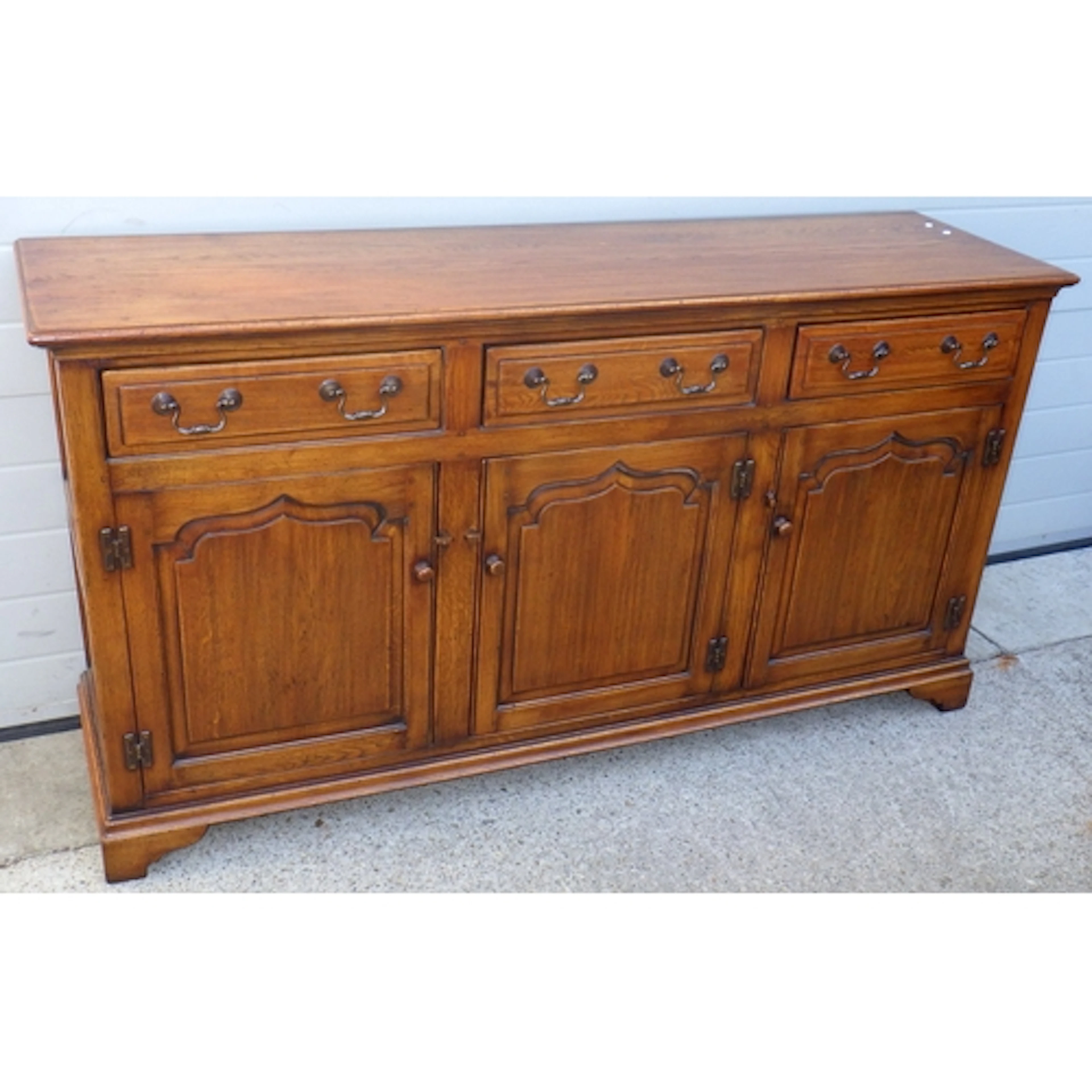 A reproduction oak three door dresser base, 169cm wide