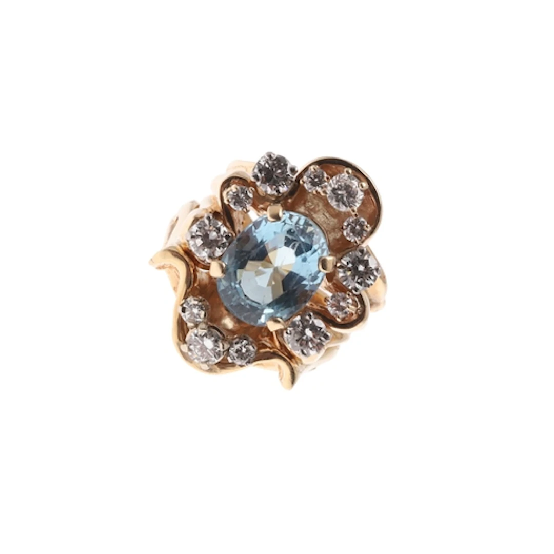 AN AQUAMARINE AND DIAMOND CLUSTER RING. the oval-shaped aqua...