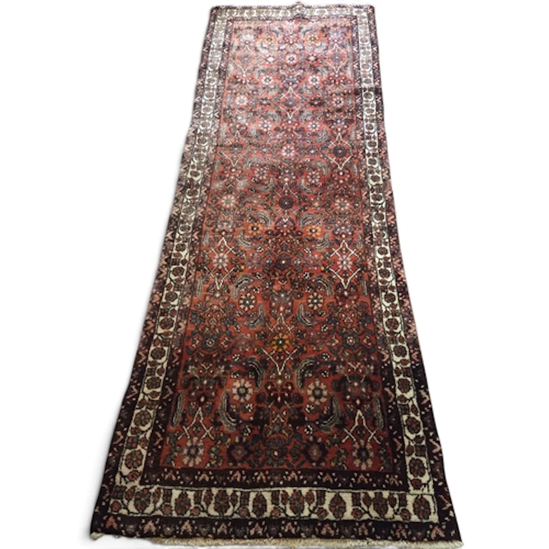 A rich red ground Persian Nahavand carpet, hand-woven with a...