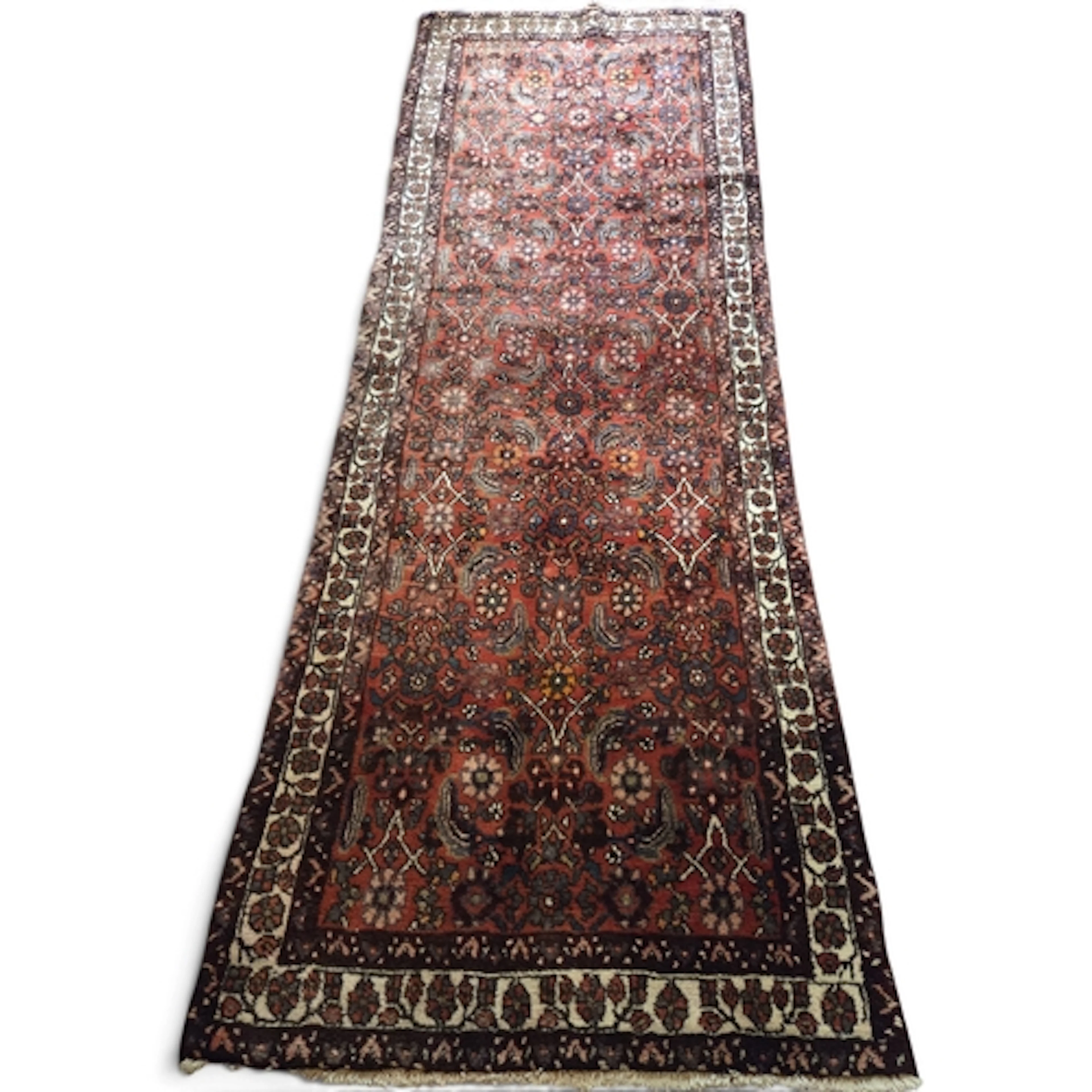 A rich red ground Persian Nahavand carpet, hand-woven with a...