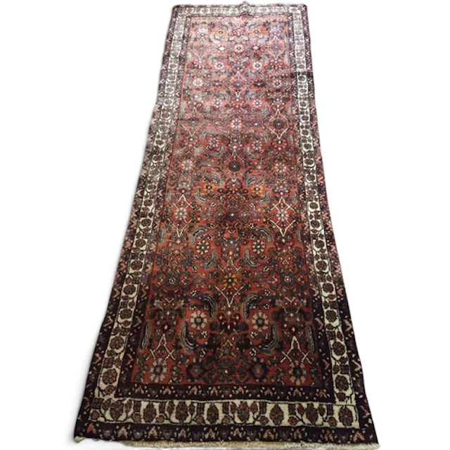A rich red ground Persian Nahavand carpet, hand-woven with a...