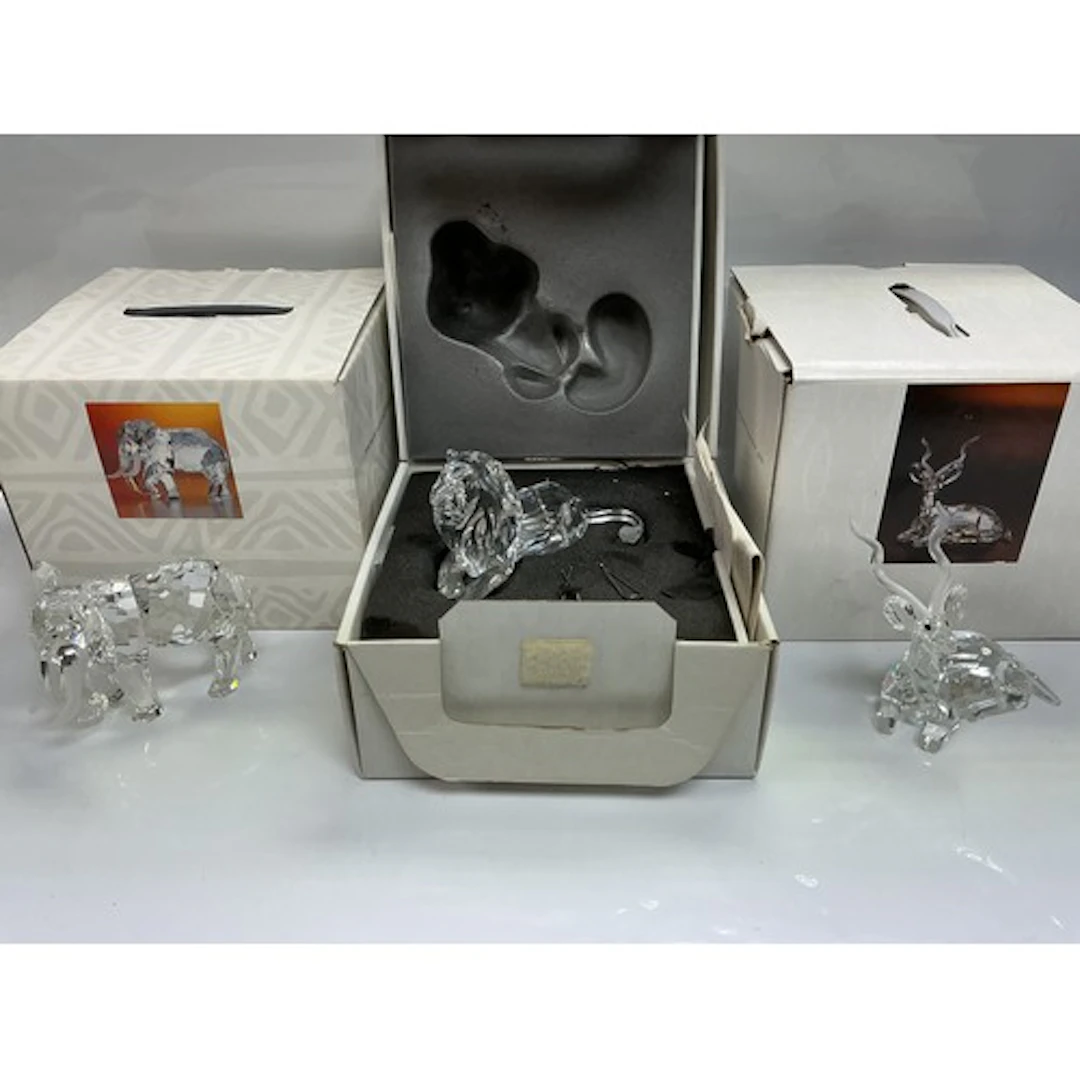 Three boxed Swarovski figures of animals comprising a lion, ...