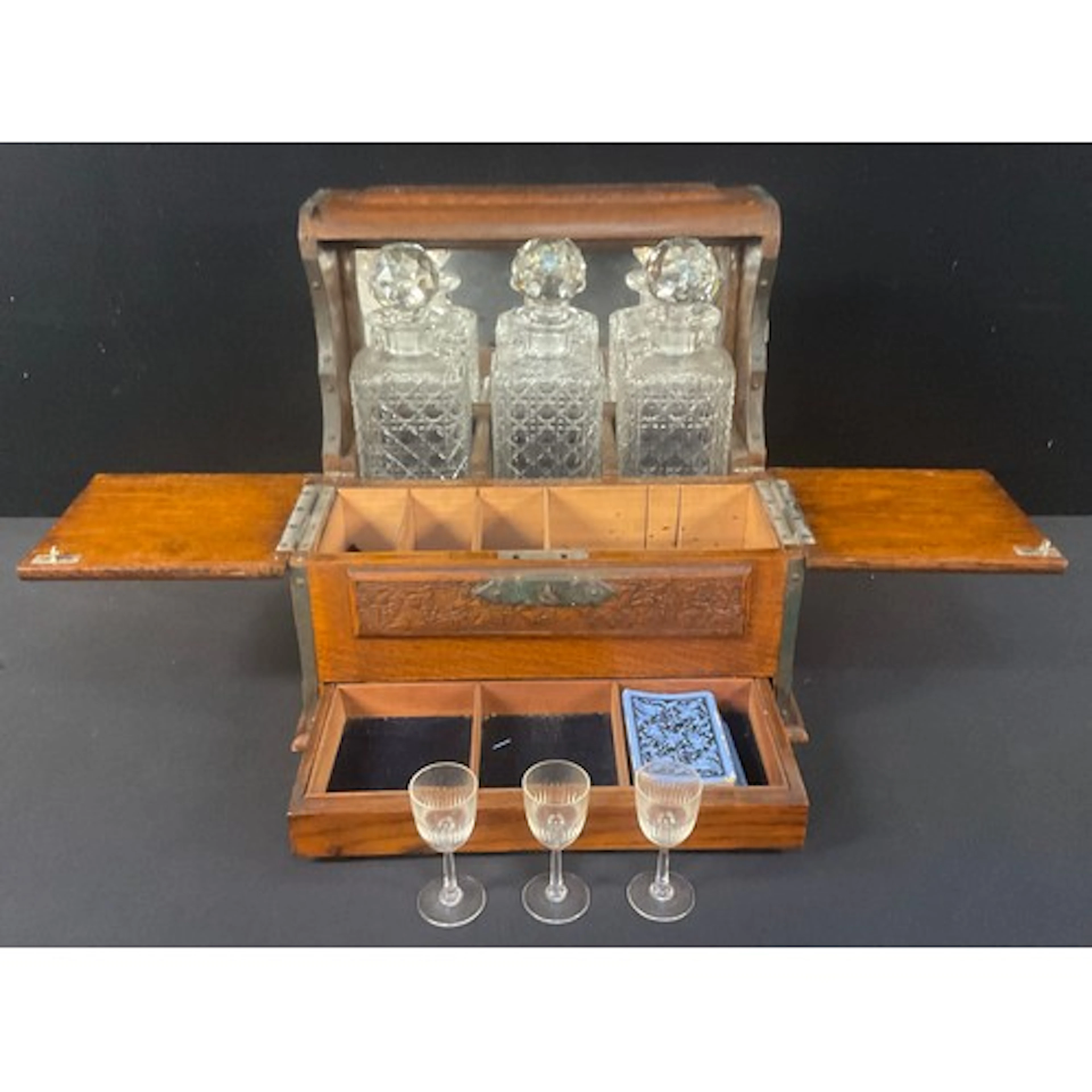 An early 20th century Arts & Crafts tantalus, the three deca...