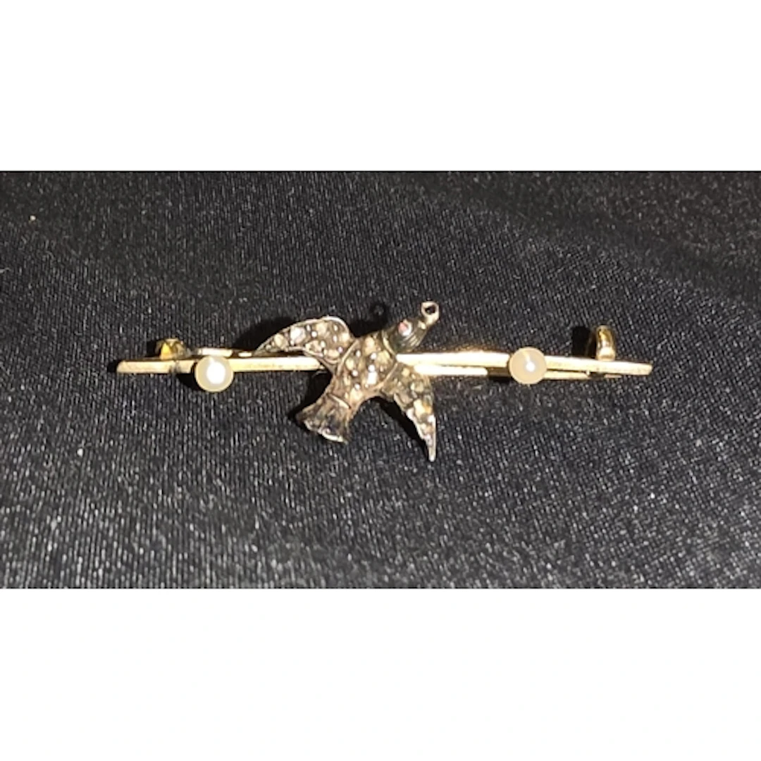 A 15ct gold brooch with bird set with old cut diamond chips,...