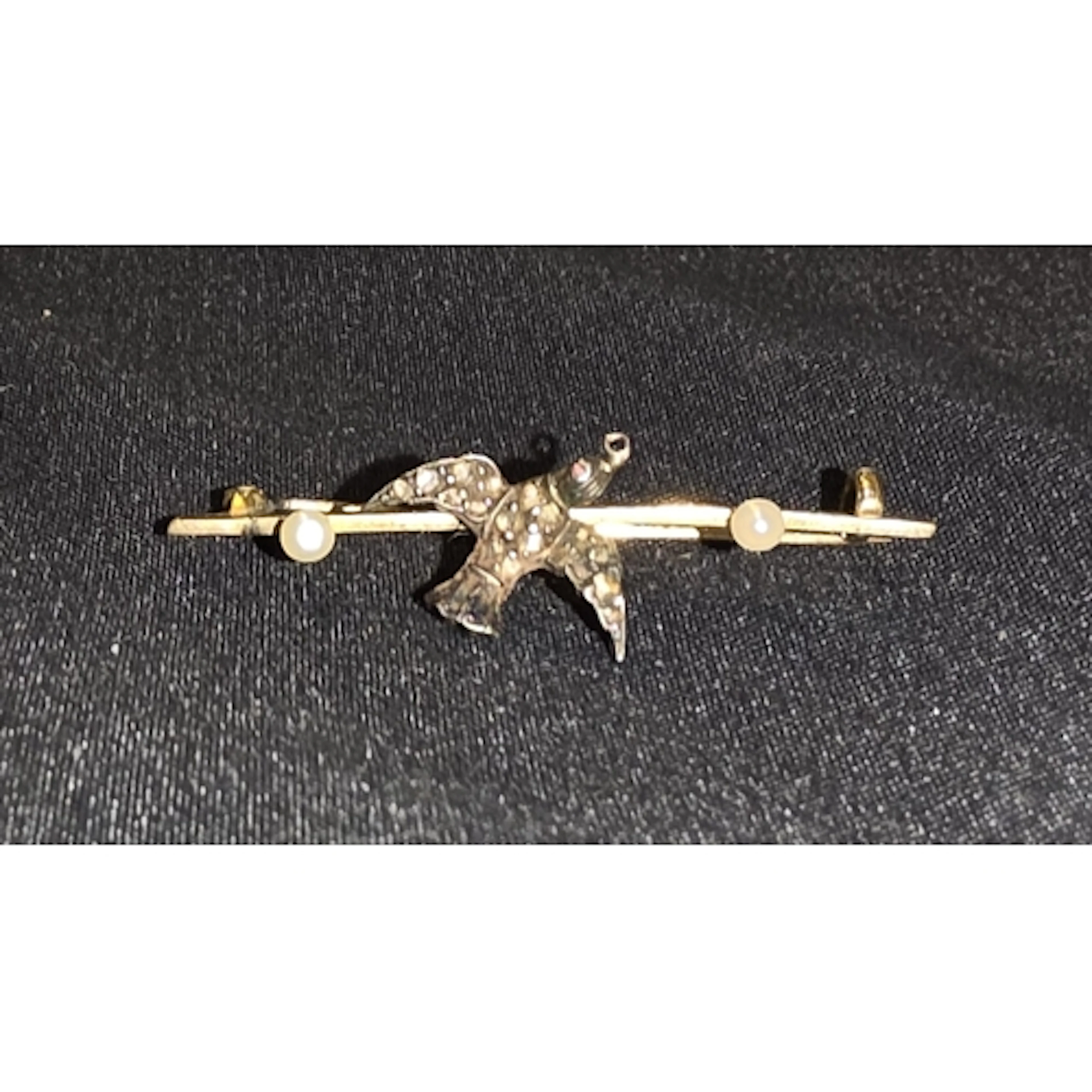 A 15ct gold brooch with bird set with old cut diamond chips,...