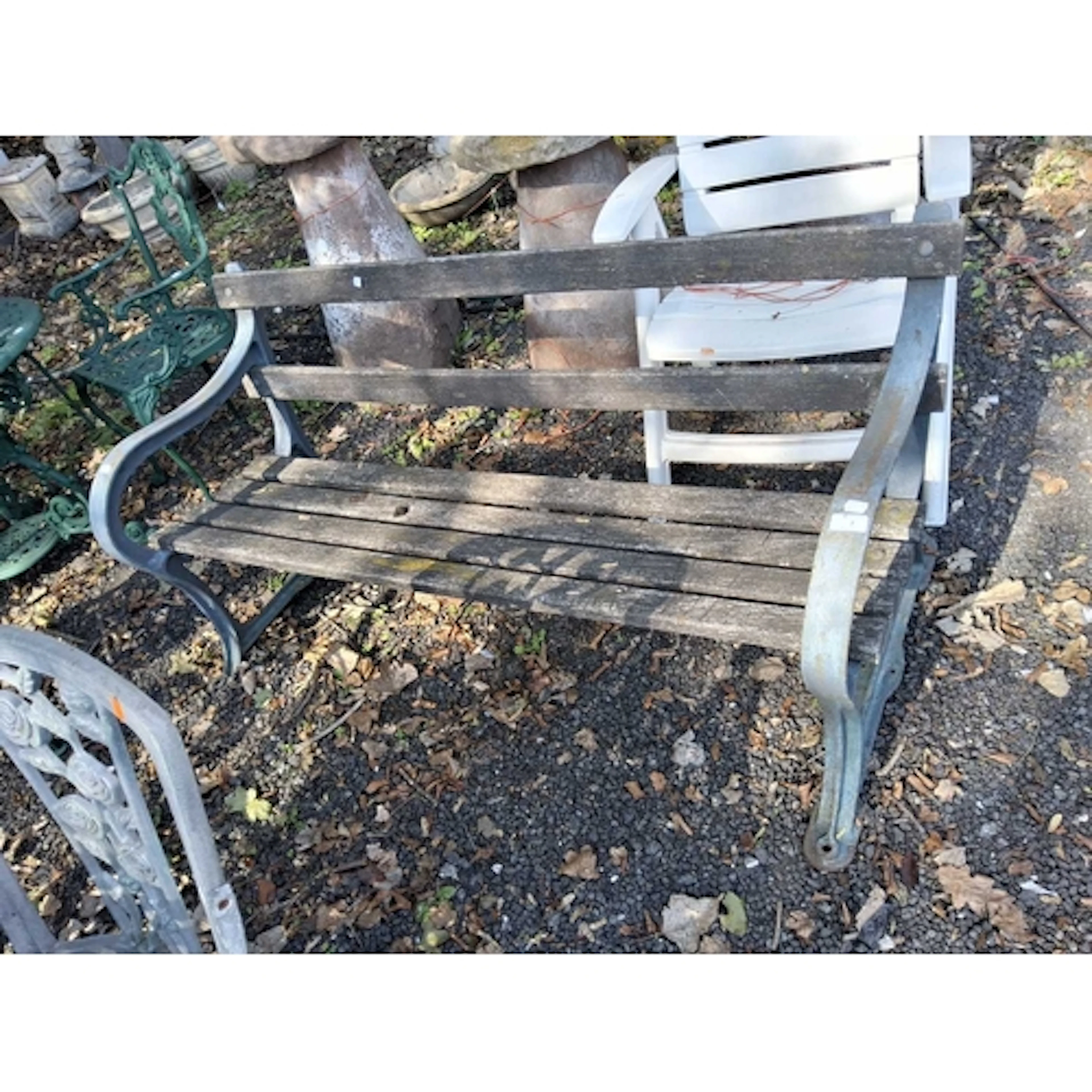 AN EARLY 20th CENTURY CAST IRON ENDED GARDEN BENCH with dist...