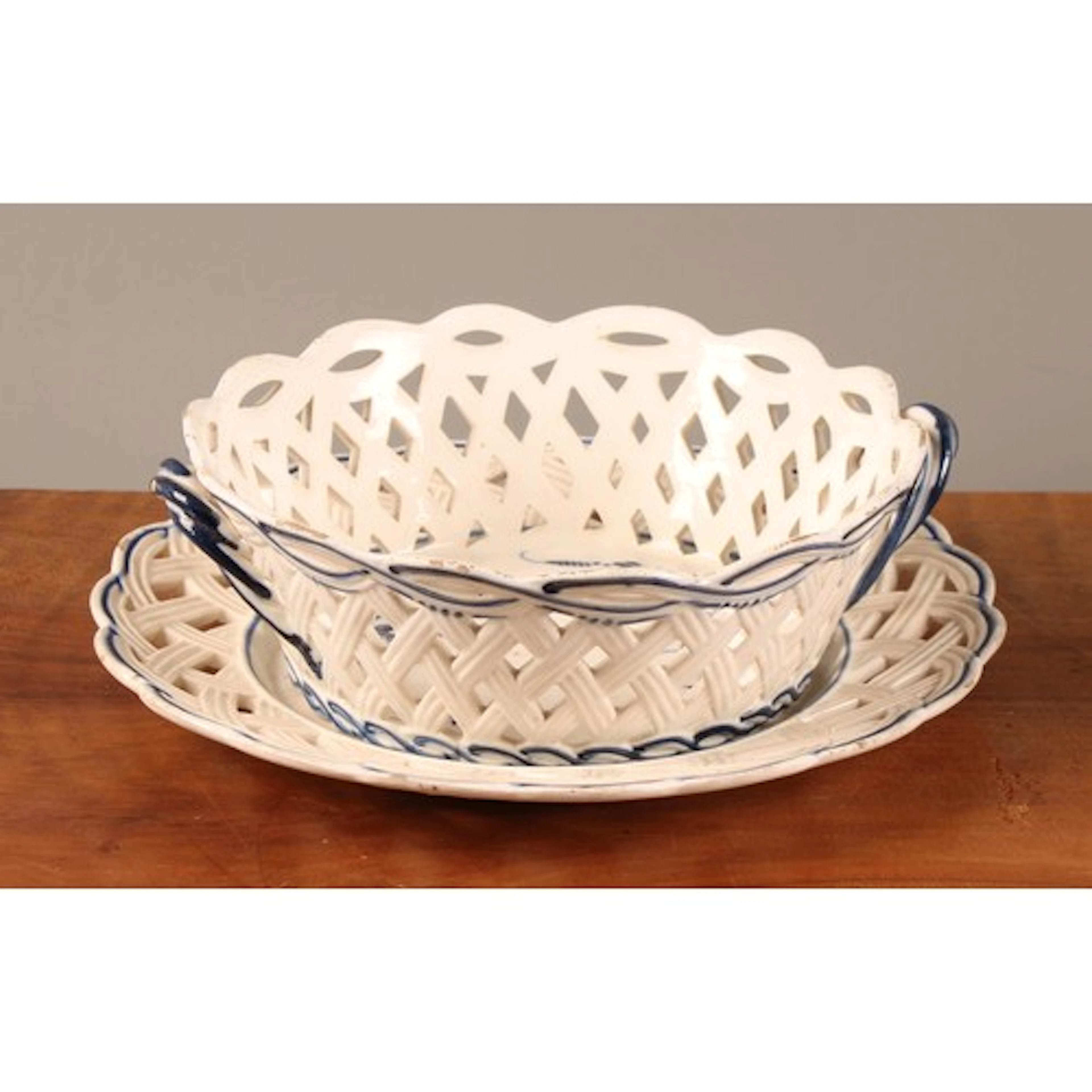 A 19th century creamware chestnut basket and stand, pierced ...