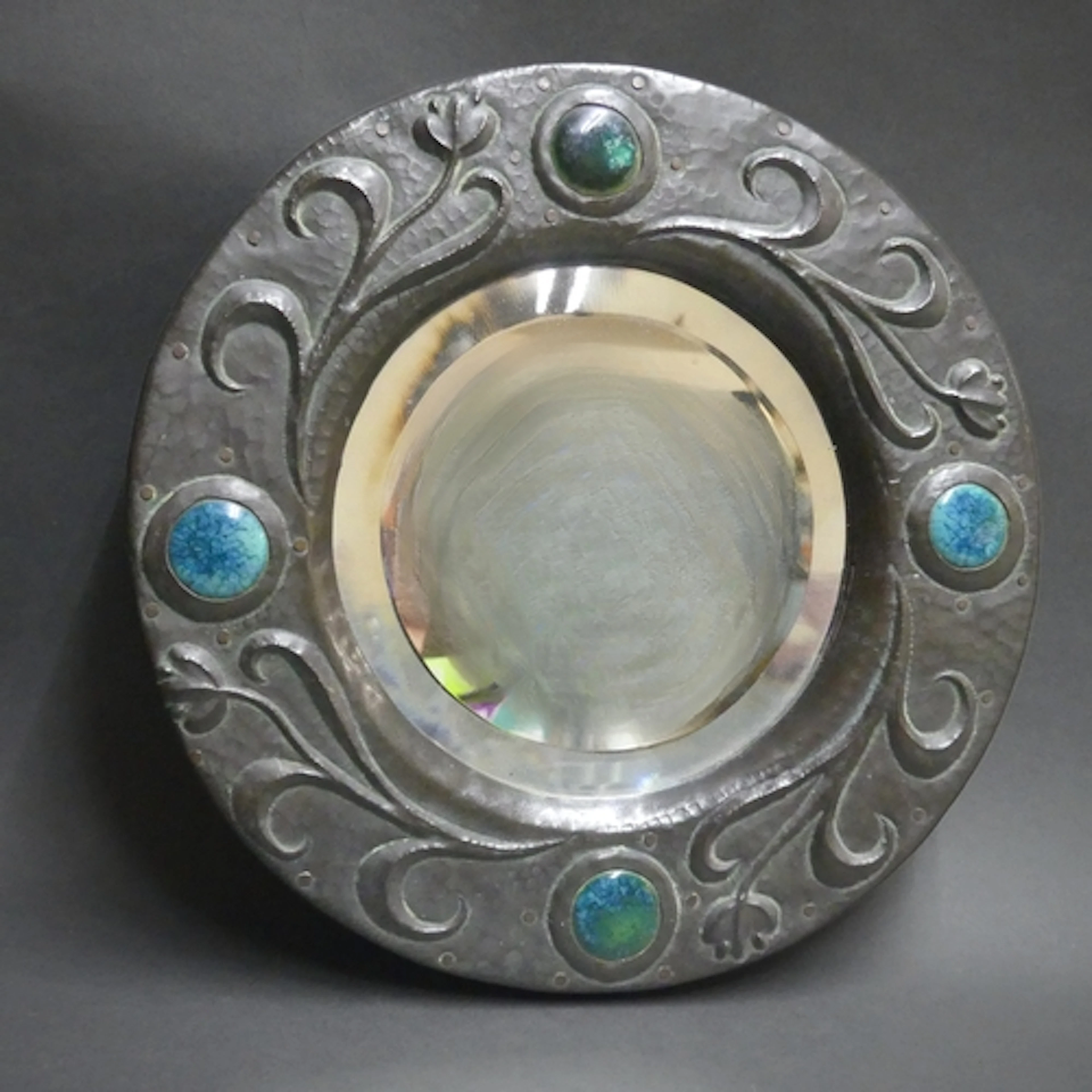An Arts and Crafts hand beaten copper clad circular bevel ed...