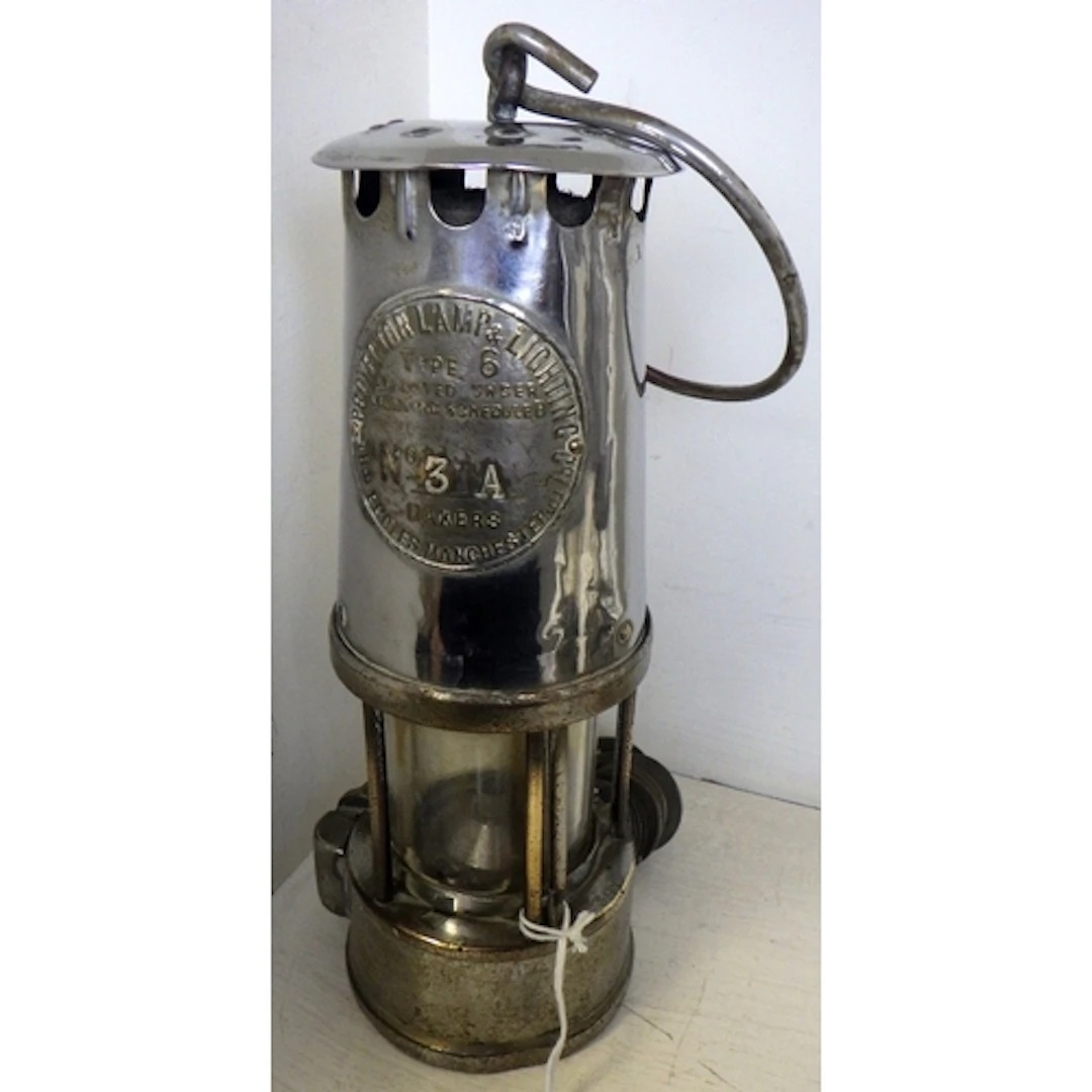 An Eccles miner's lamp with a qty of pit checks
