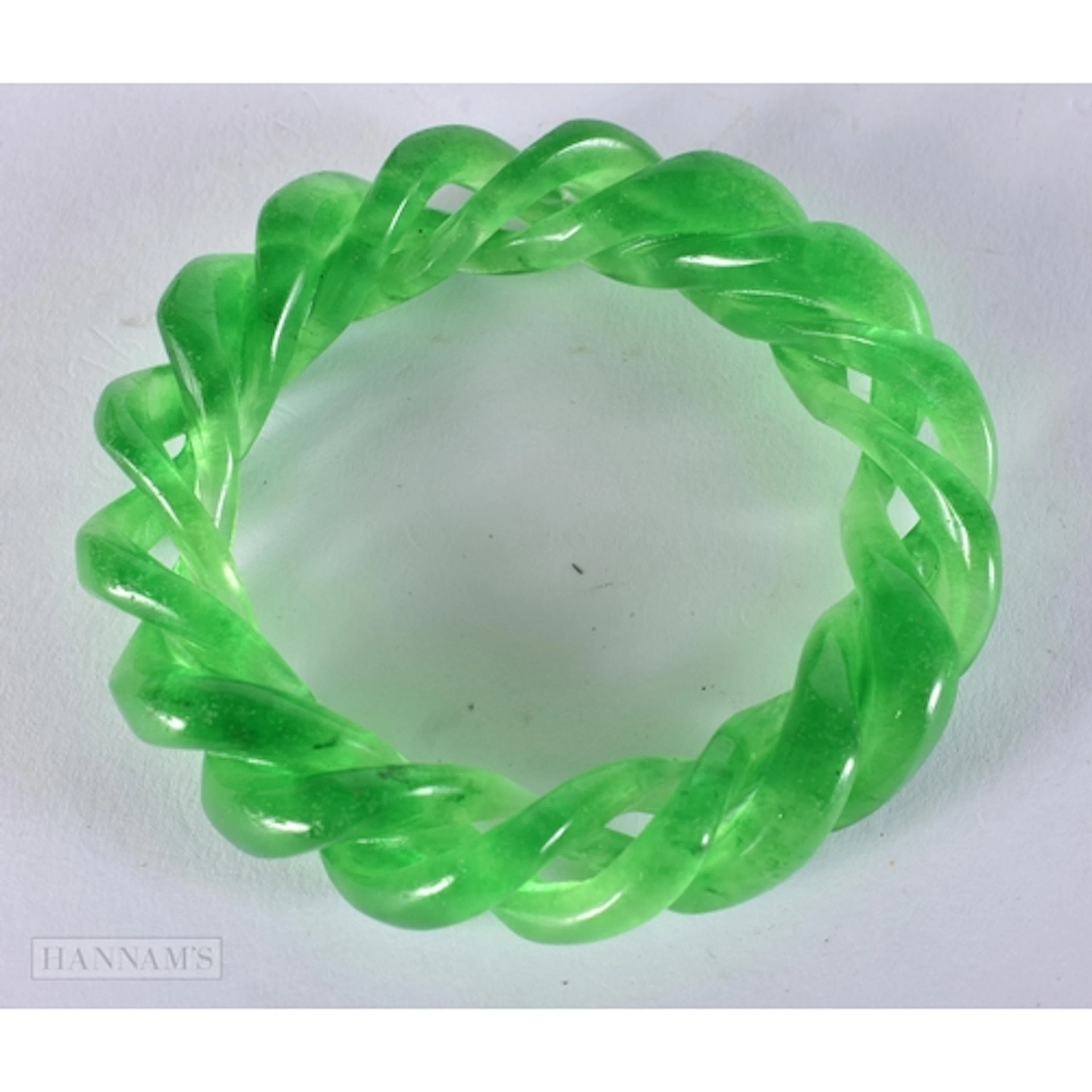 A GREEN JADE TWIST BANGLE. 6.5 cm internal diameter