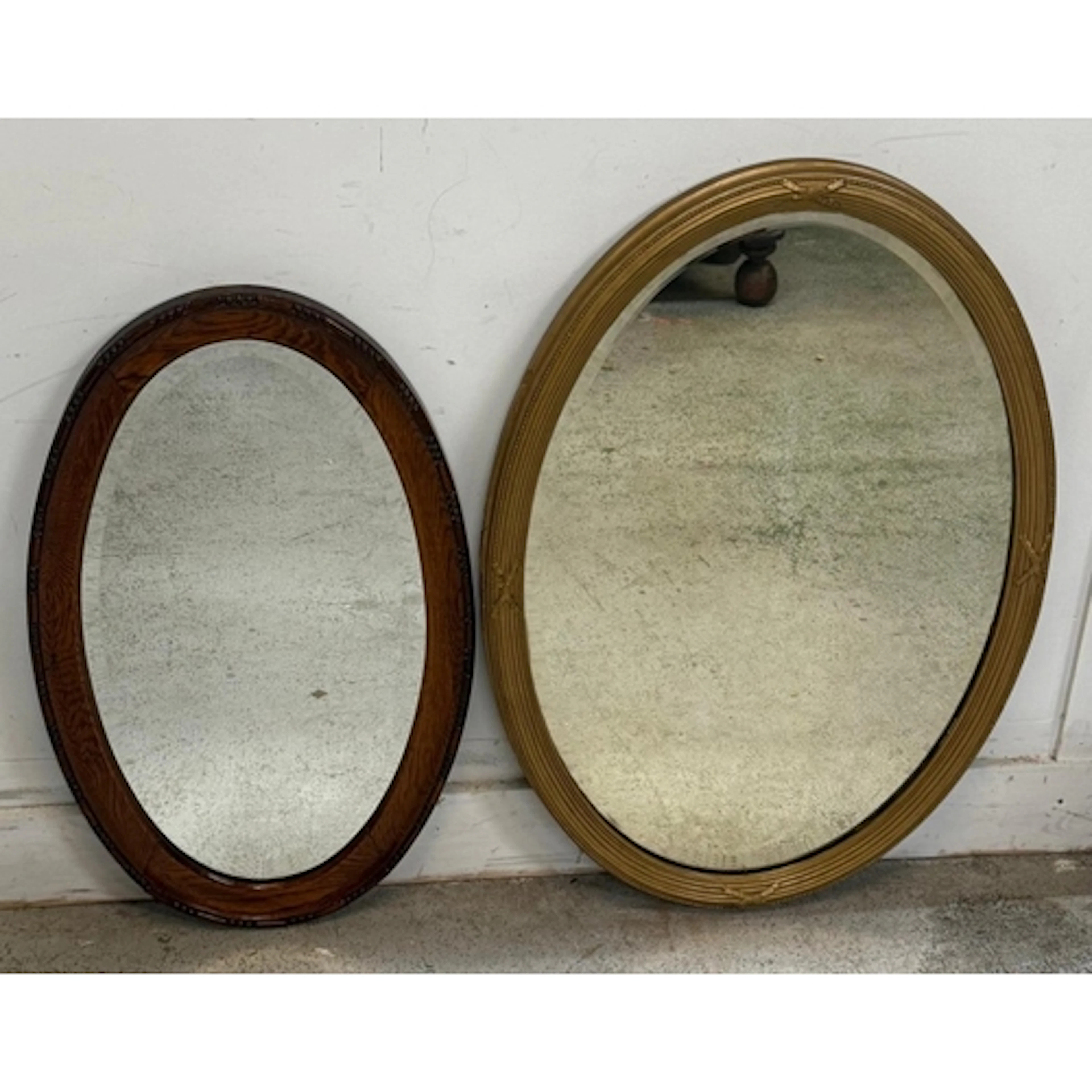 A gold-painted oval hall mirror, together with a mahogany ov...