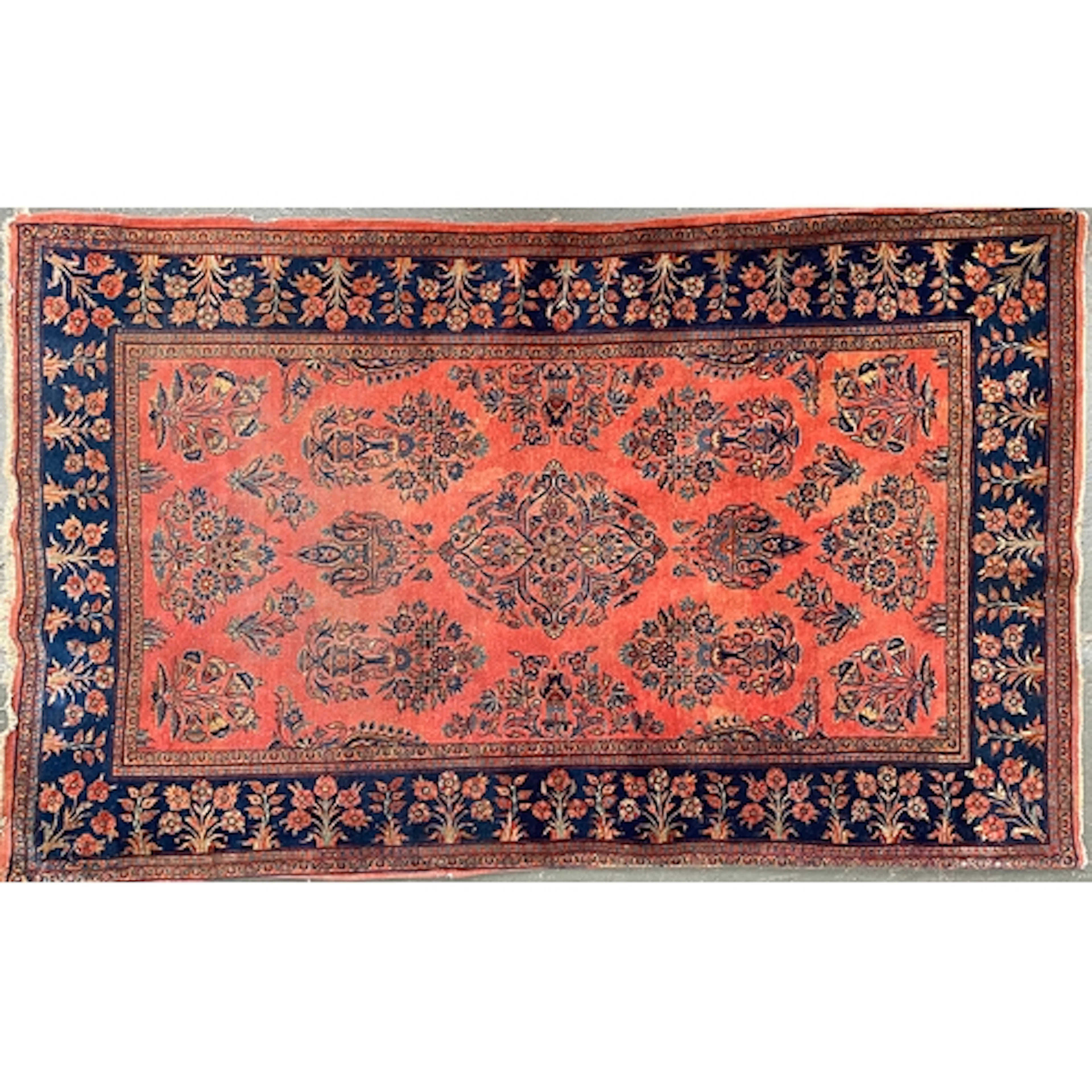 A Sarouk style red ground rug, the blue border with floral m...
