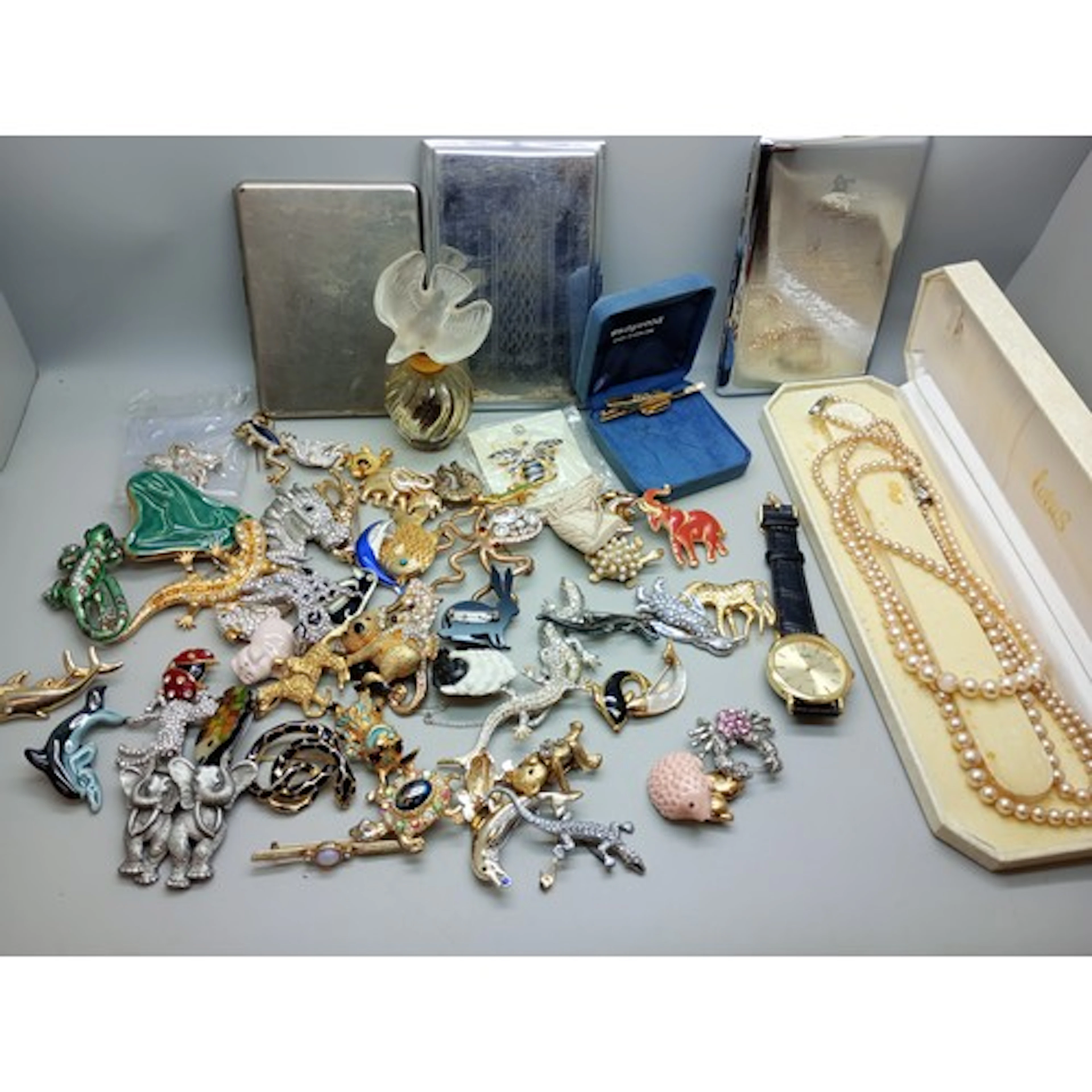 A collection of costume brooches, faux pearls, a silver broo...