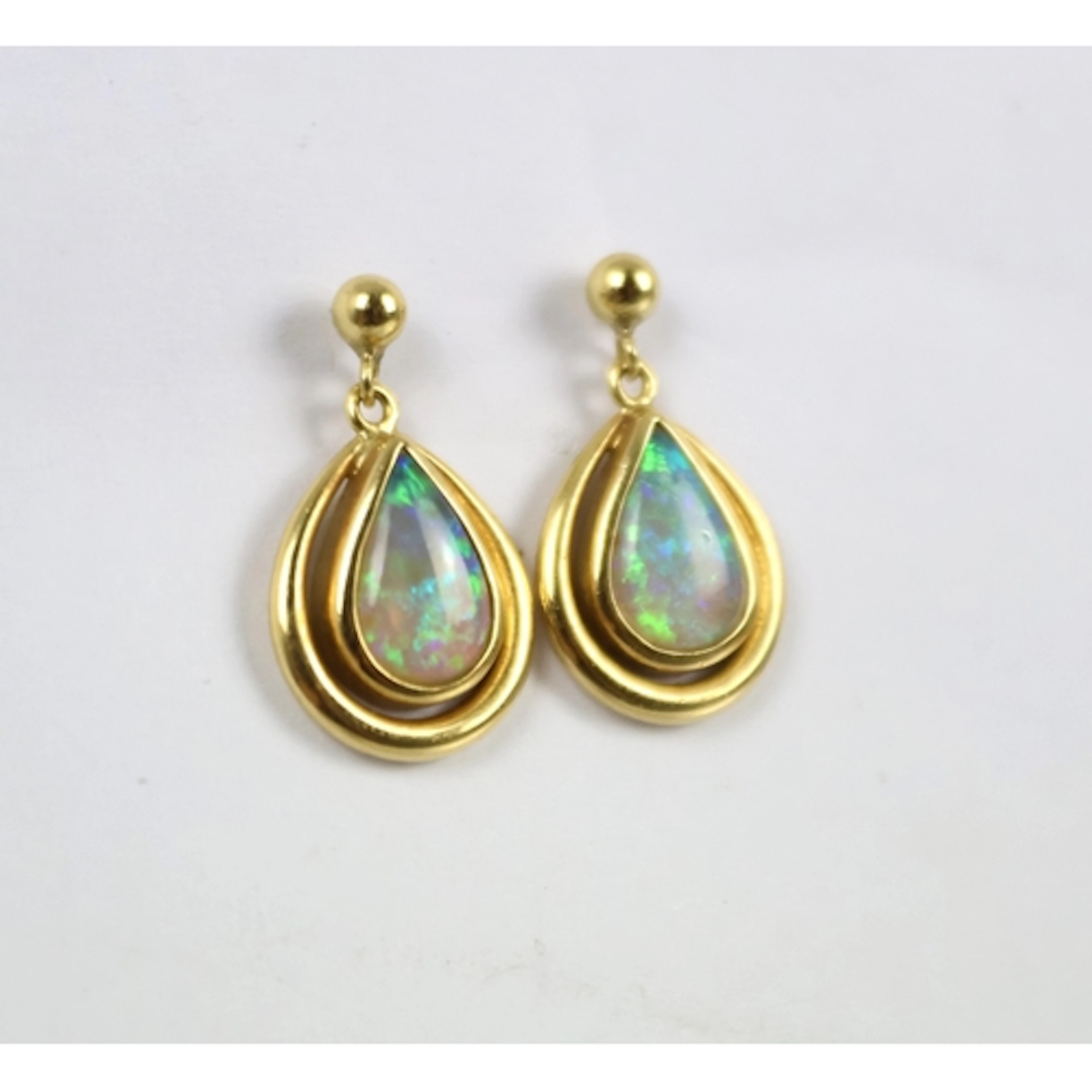 A pair of contemporary opal drop earrings, each designed as ...