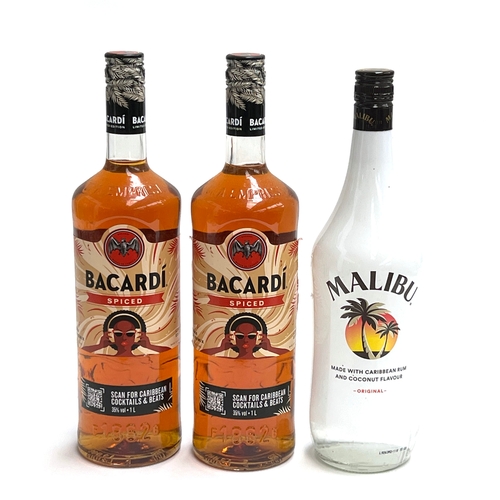 Two bottles of Bacardi spiced rum, 1L; and a bottle of Malib...
