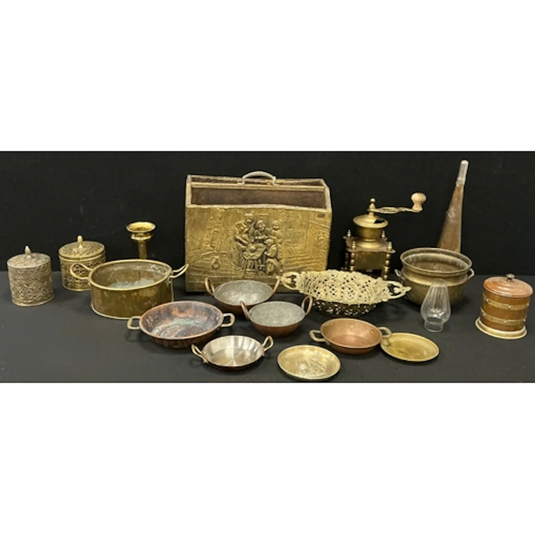 An embossed brass magazine rack; a coffee grinder; brass foo...