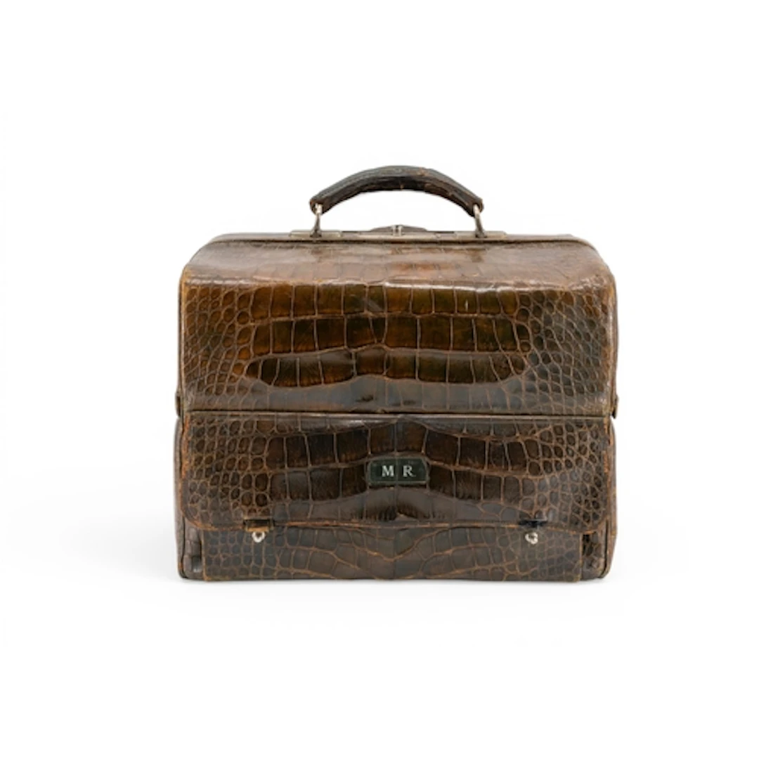 A FAUX CROCODILE TRAVELLING TOILET BAG with green silk-lined...
