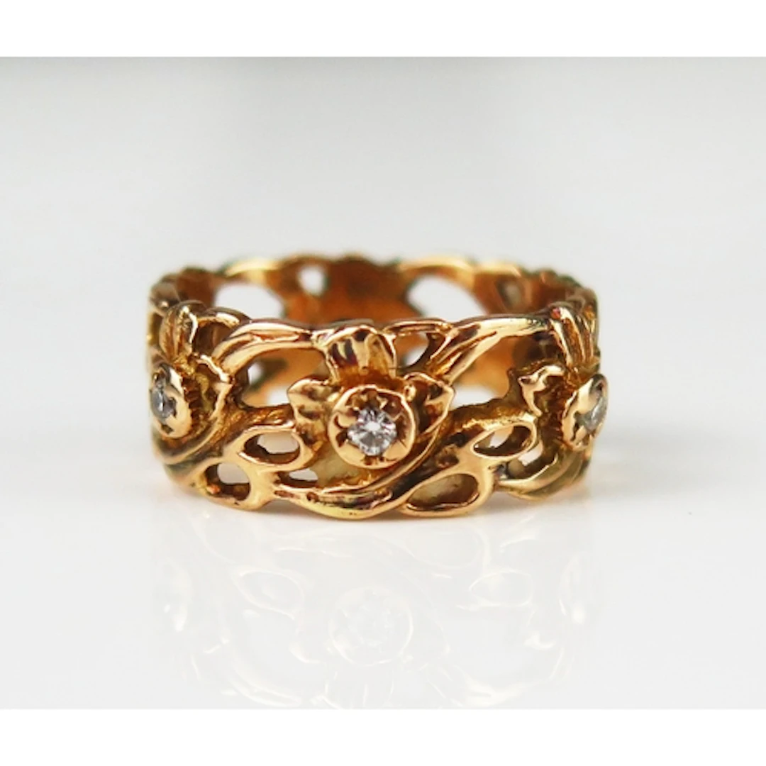 A diamond set pierced foliate decorated wedding band, 8.61mm...