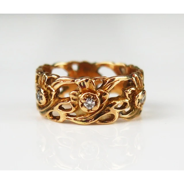 A diamond set pierced foliate decorated wedding band, 8.61mm...