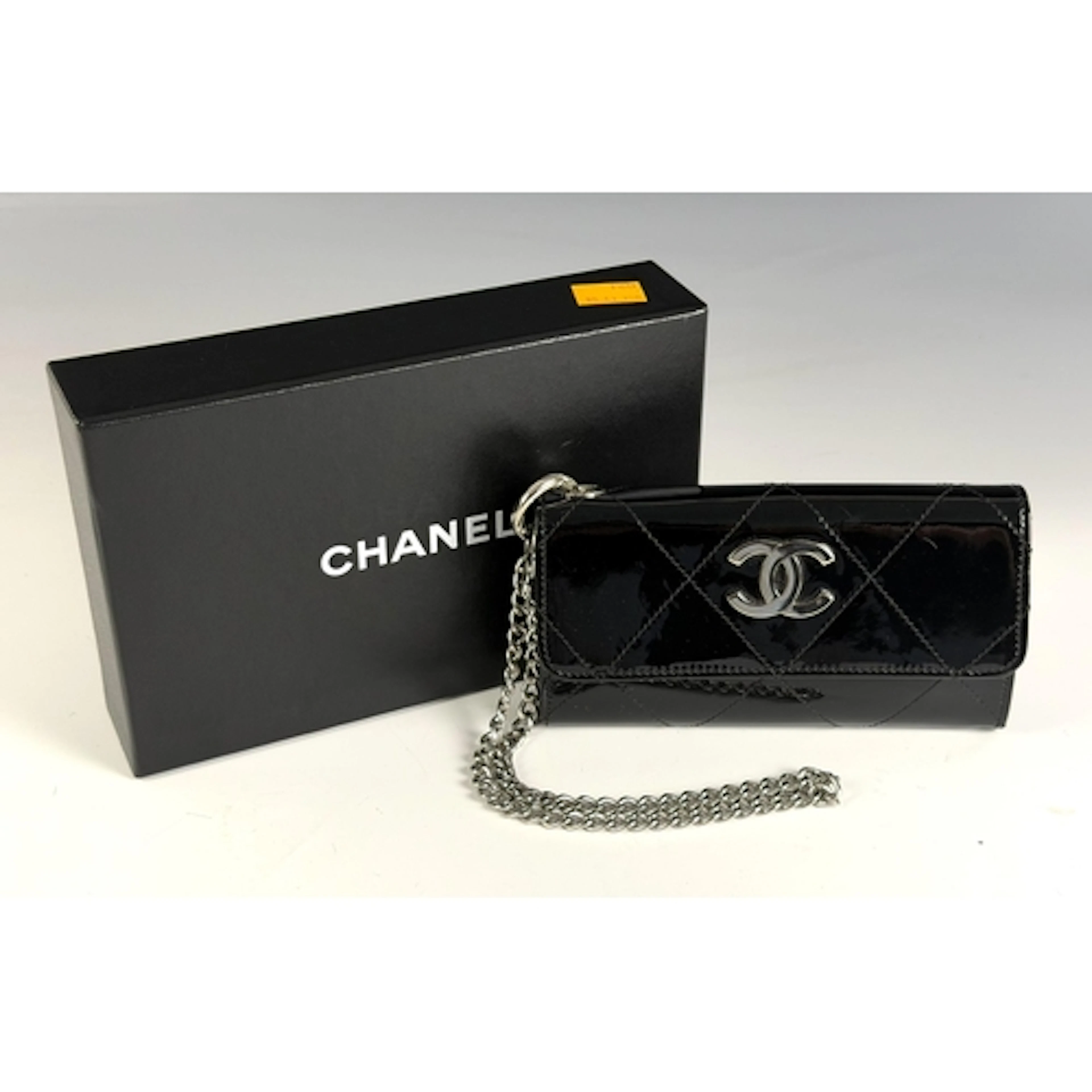 A Chanel patent leather quilted black purse with silver hard...