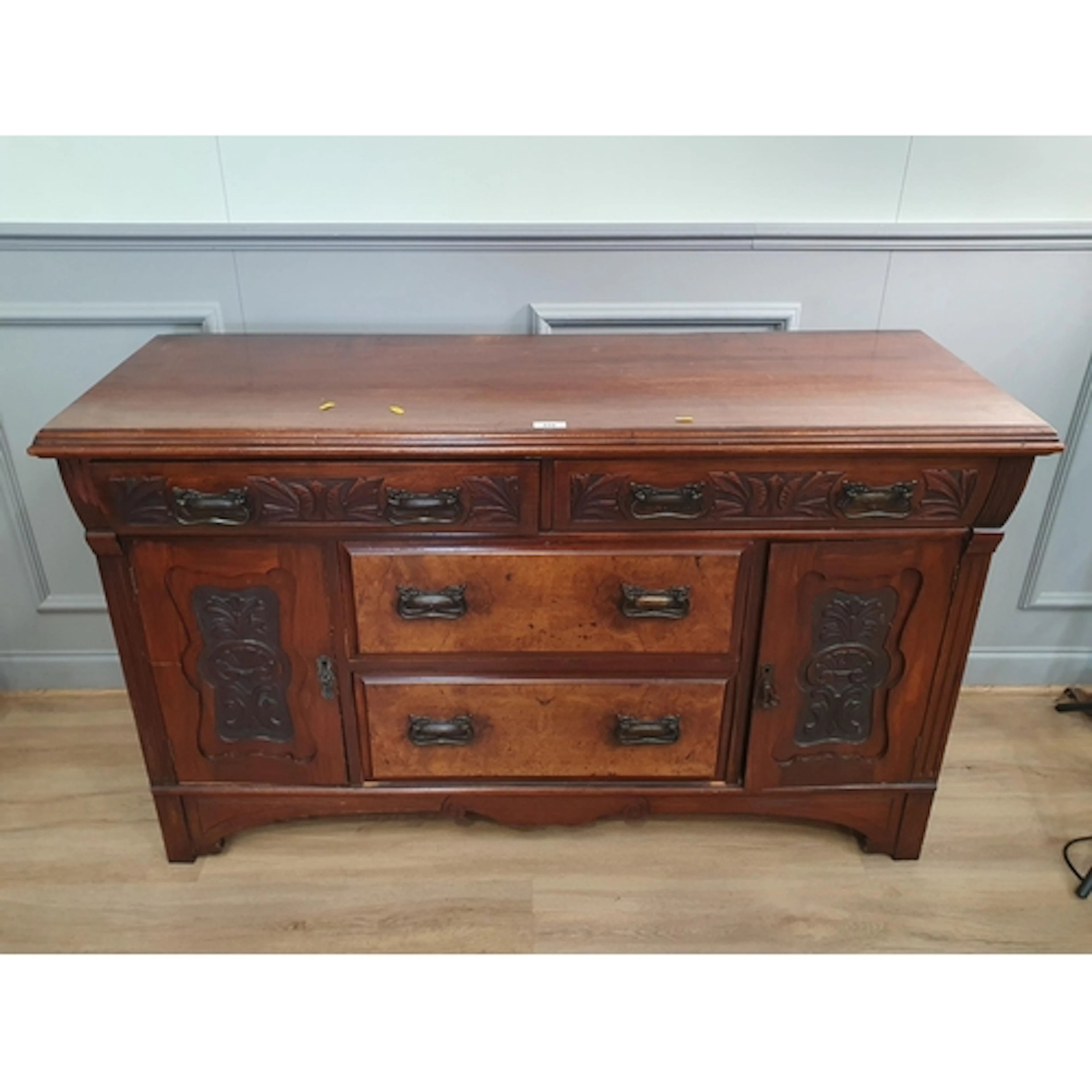 A carved walnut Art Deco style Sideboard featuring two long ...