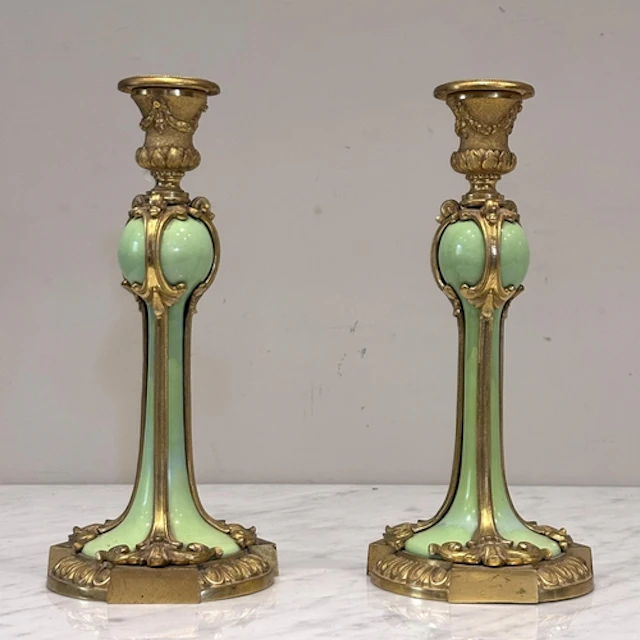 A pair of ormolu mounted and porcelain inset Rococo candlest...