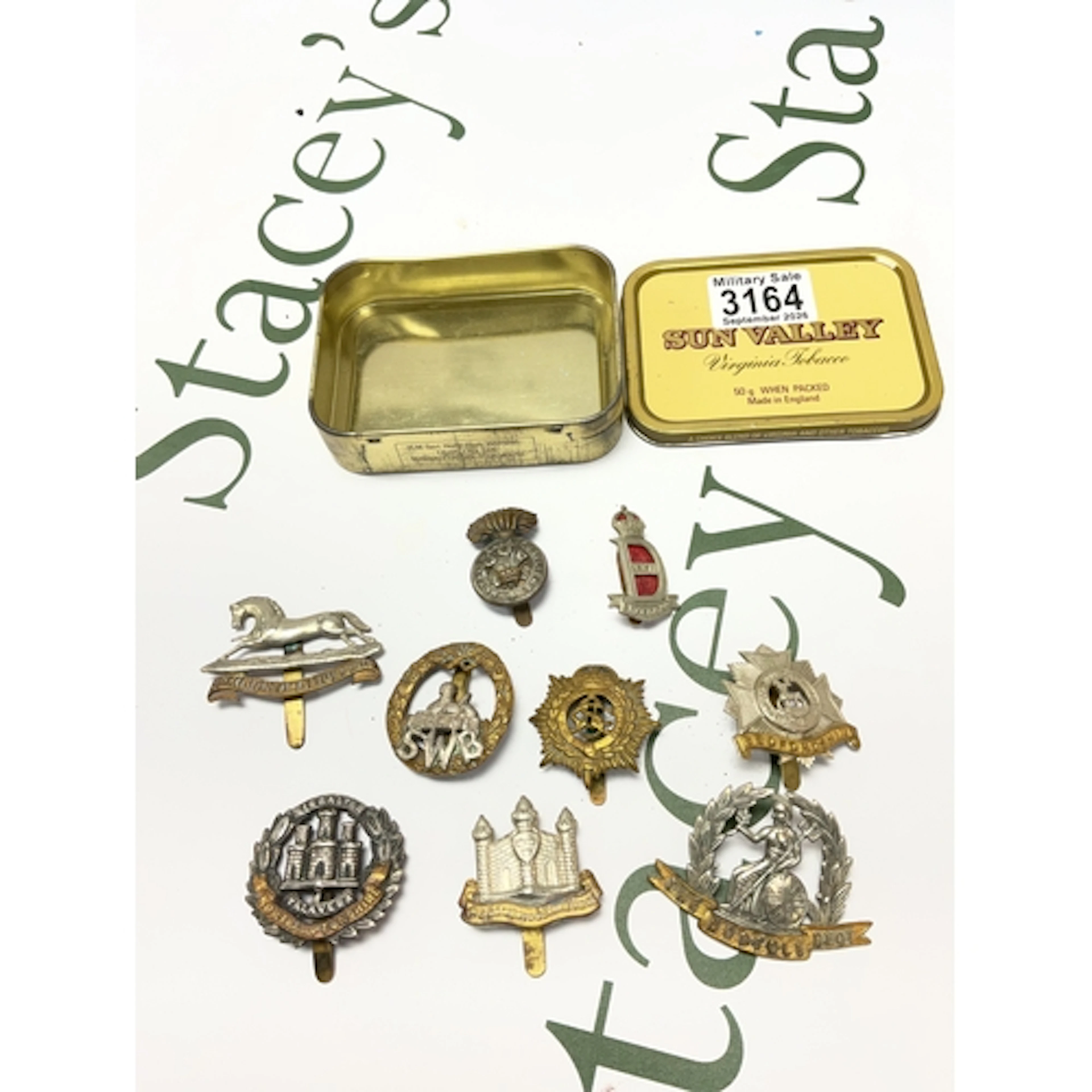 Tin of mixed military cap badges.