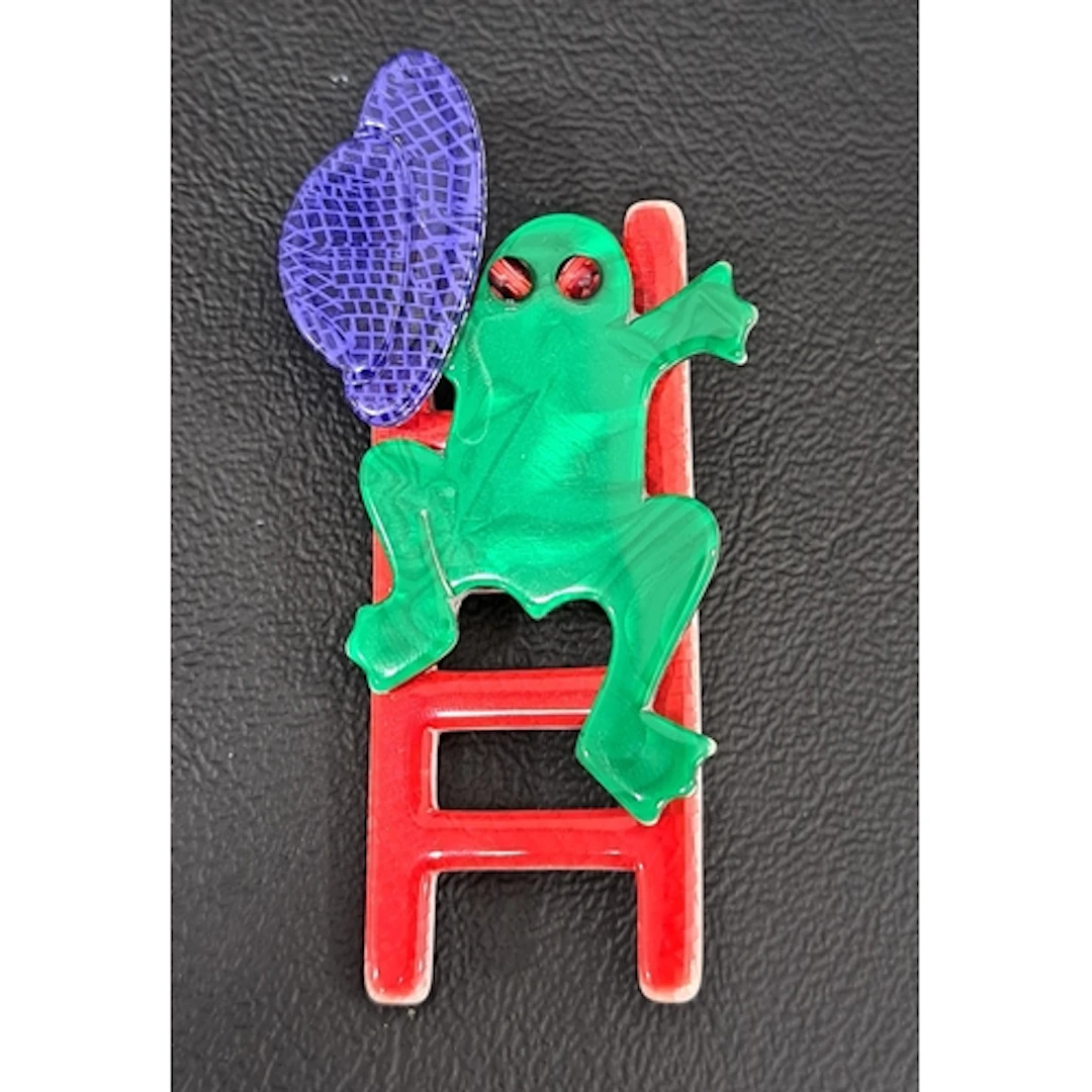LEA STEIN FROG BROOCH the opalescent green frog holding a bl...